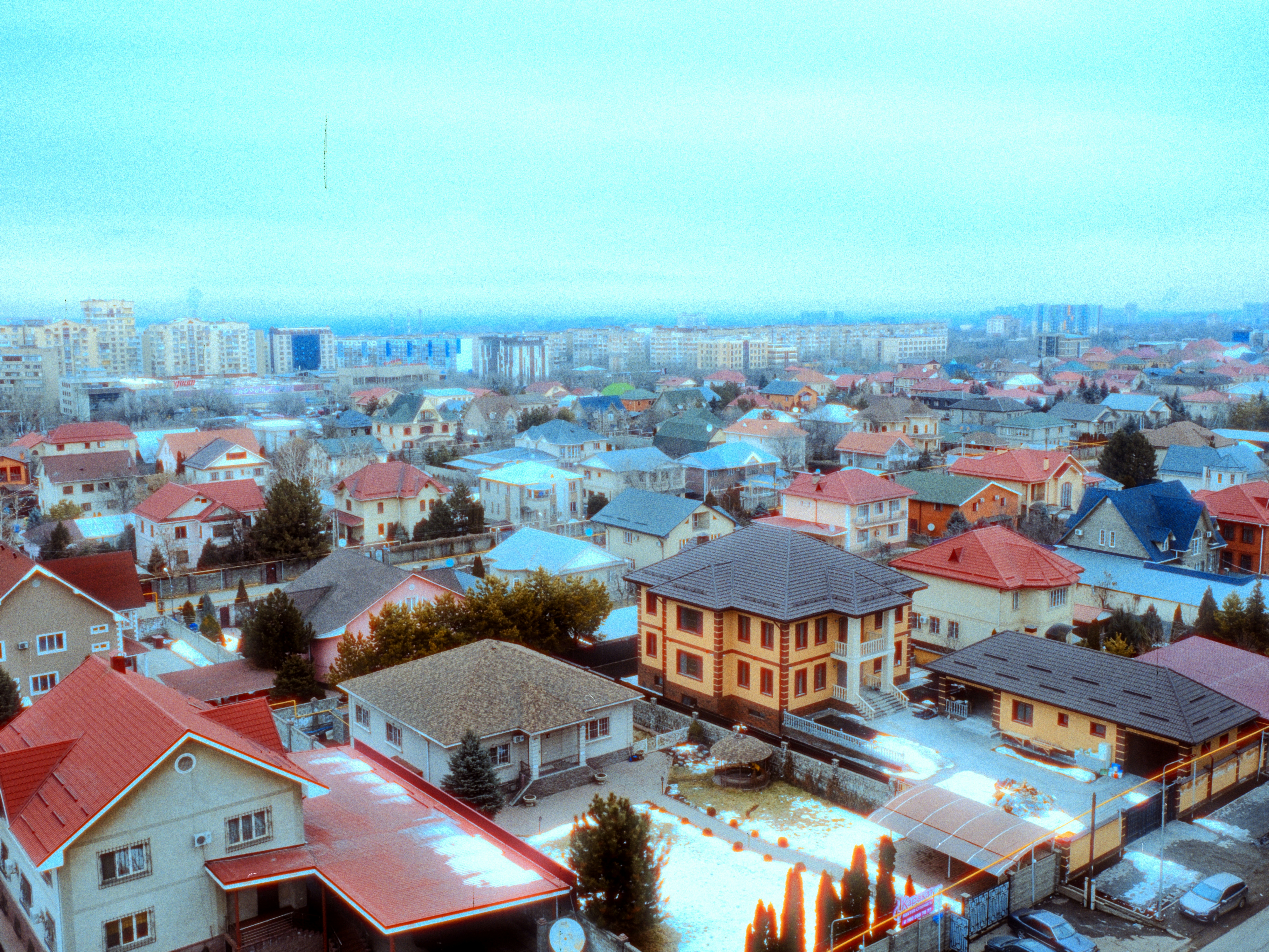 A suburban neighborhood with houses and distant city buildings.