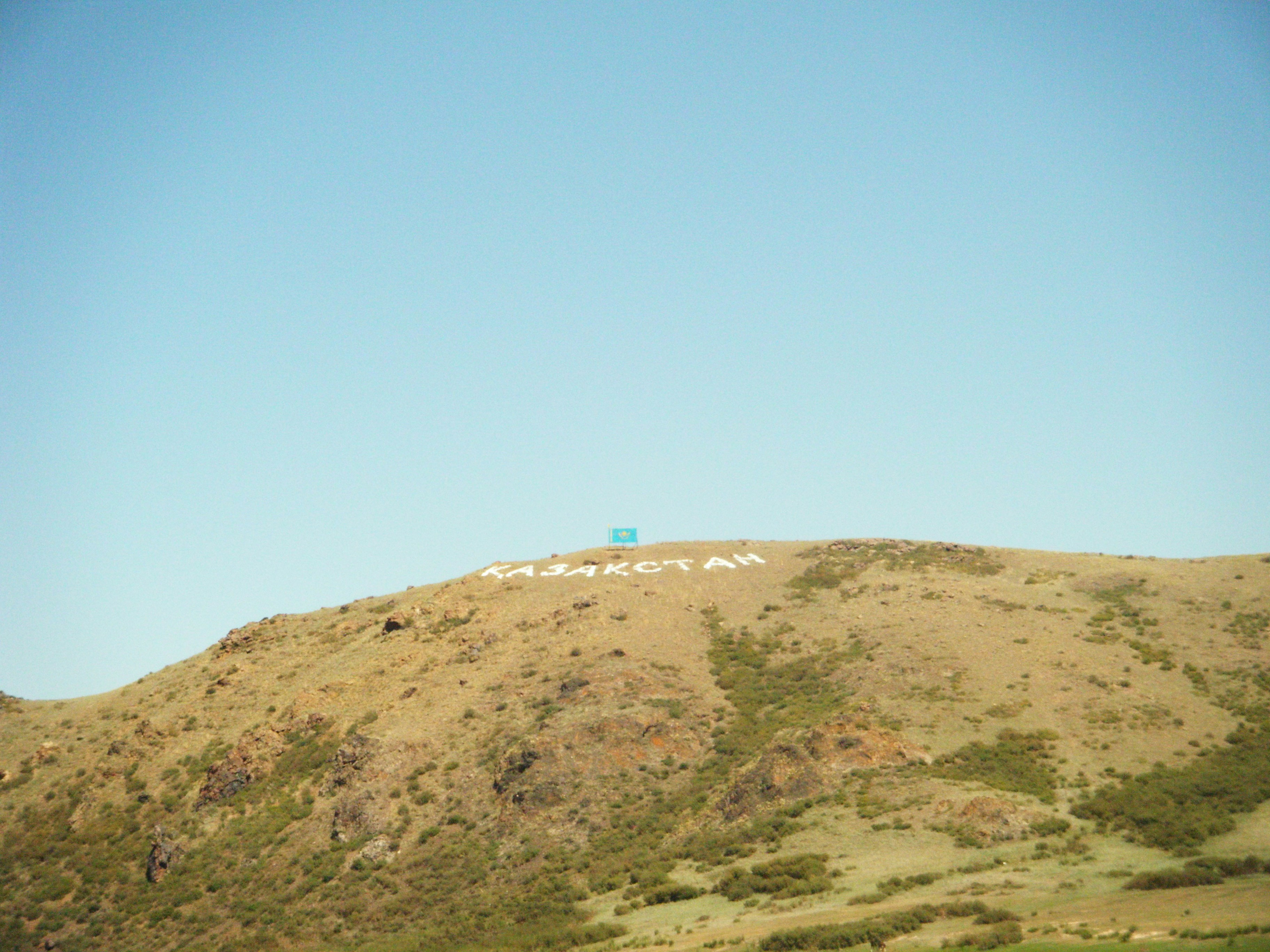 Hillside with white lettering against a clear blue sky
