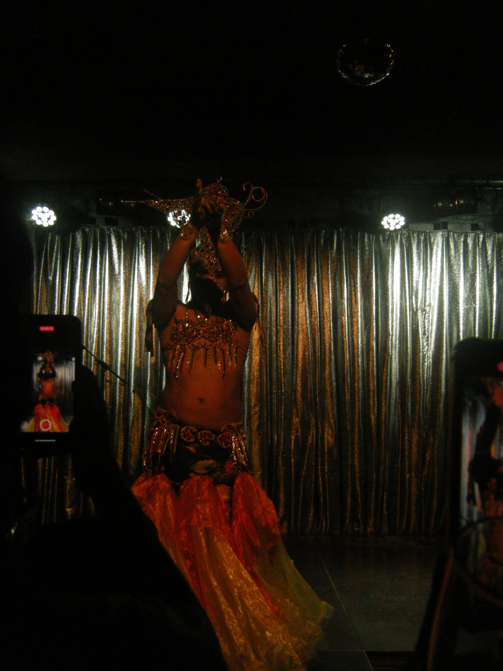 Female performer in ornate costume dancing on stage