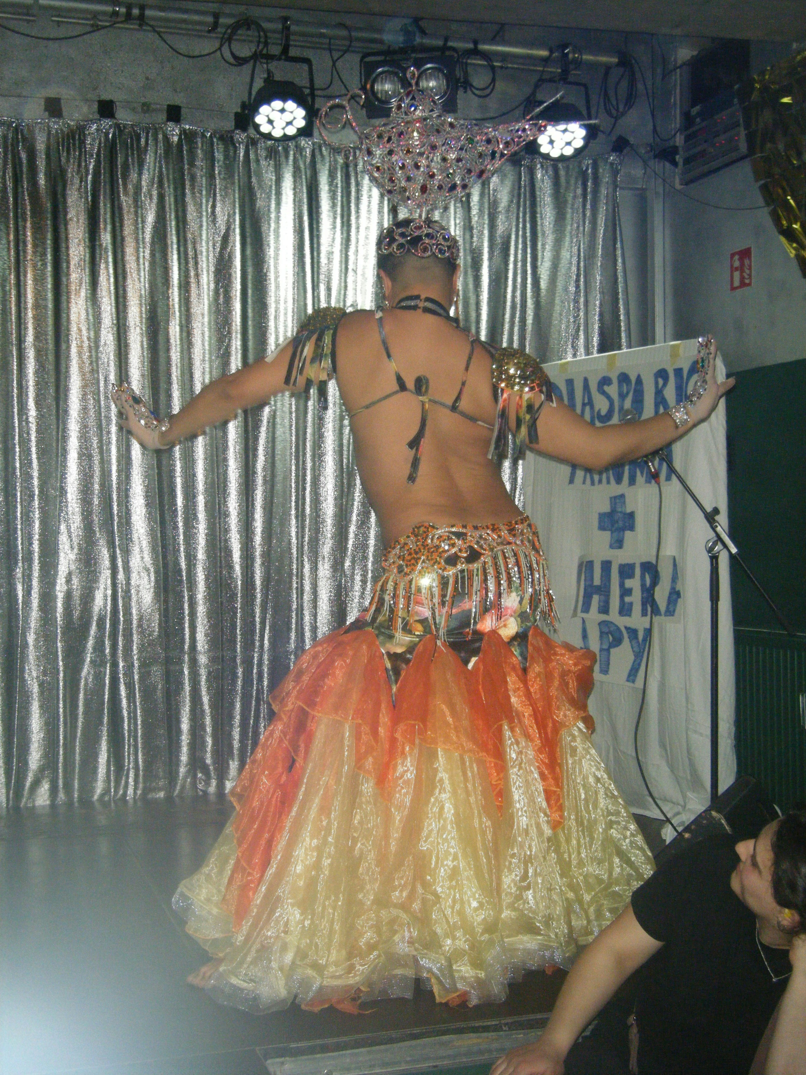 Performer in elaborate costume dances on stage