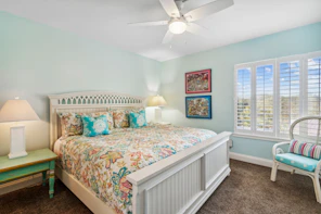 A bright, coastal-themed bedroom with a large bed.