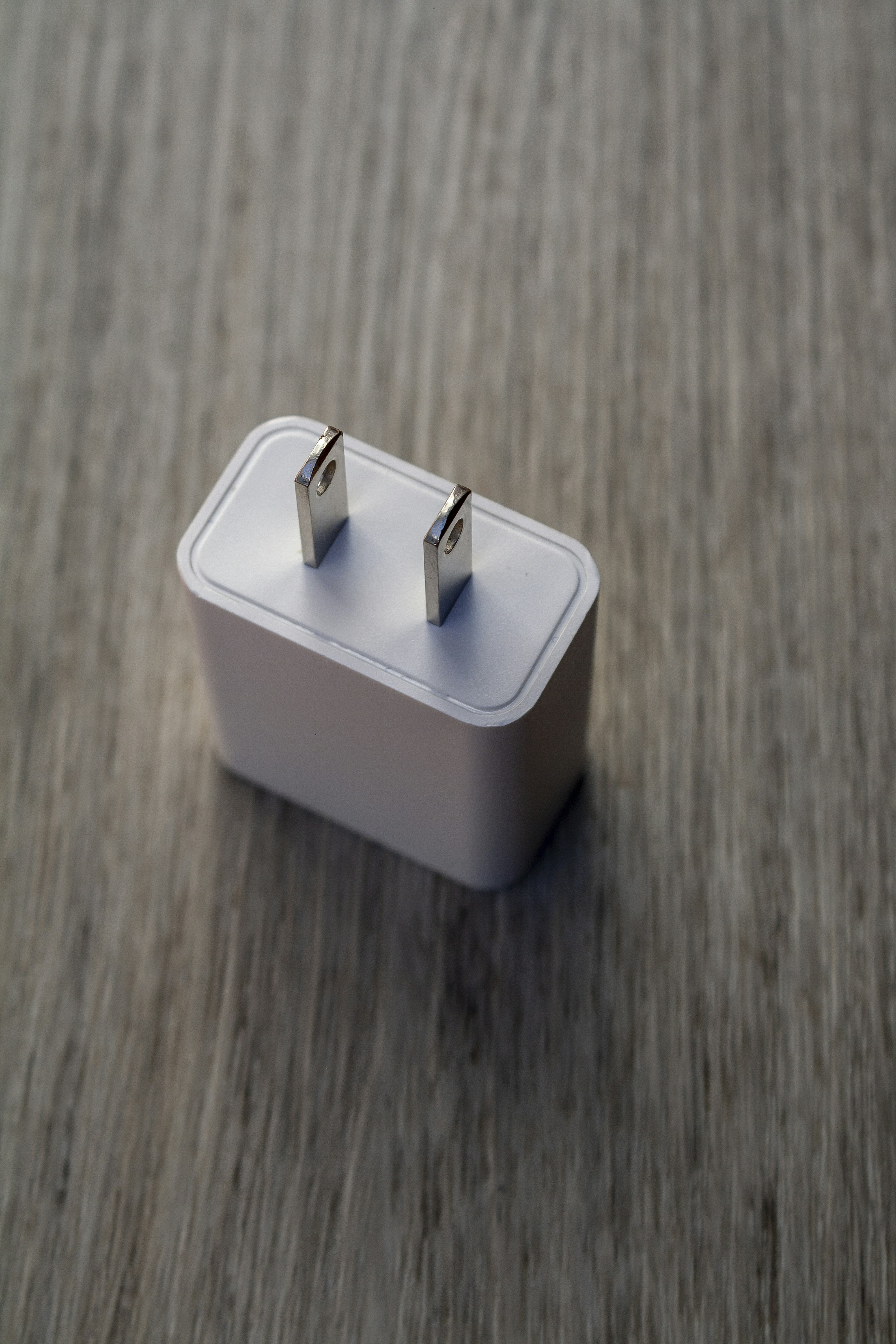 White power adapter with metal prongs on wood