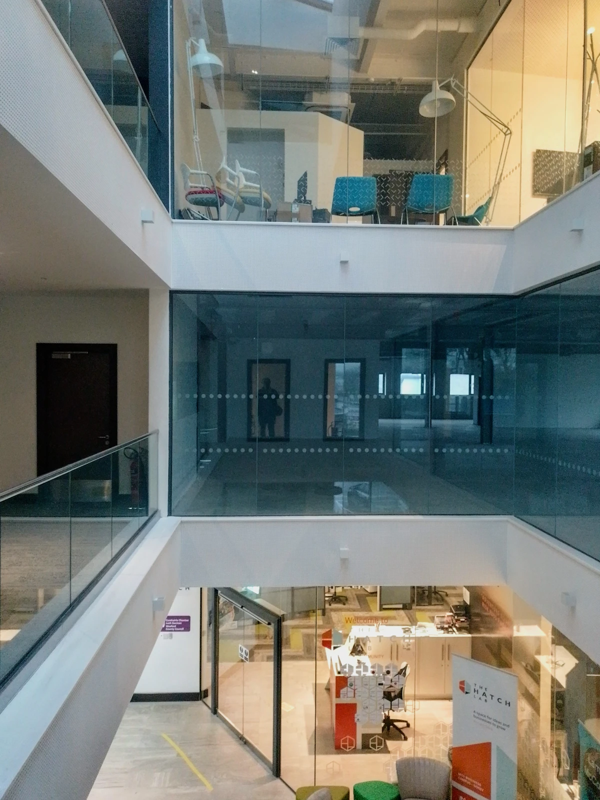 Interior contemporáneo de espacio de trabajo con vidrio y varios niveles