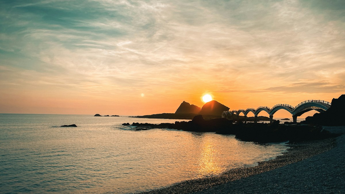 台東三仙台的八拱跨海步橋與離岸島，太陽從島嶼後方的海面升起