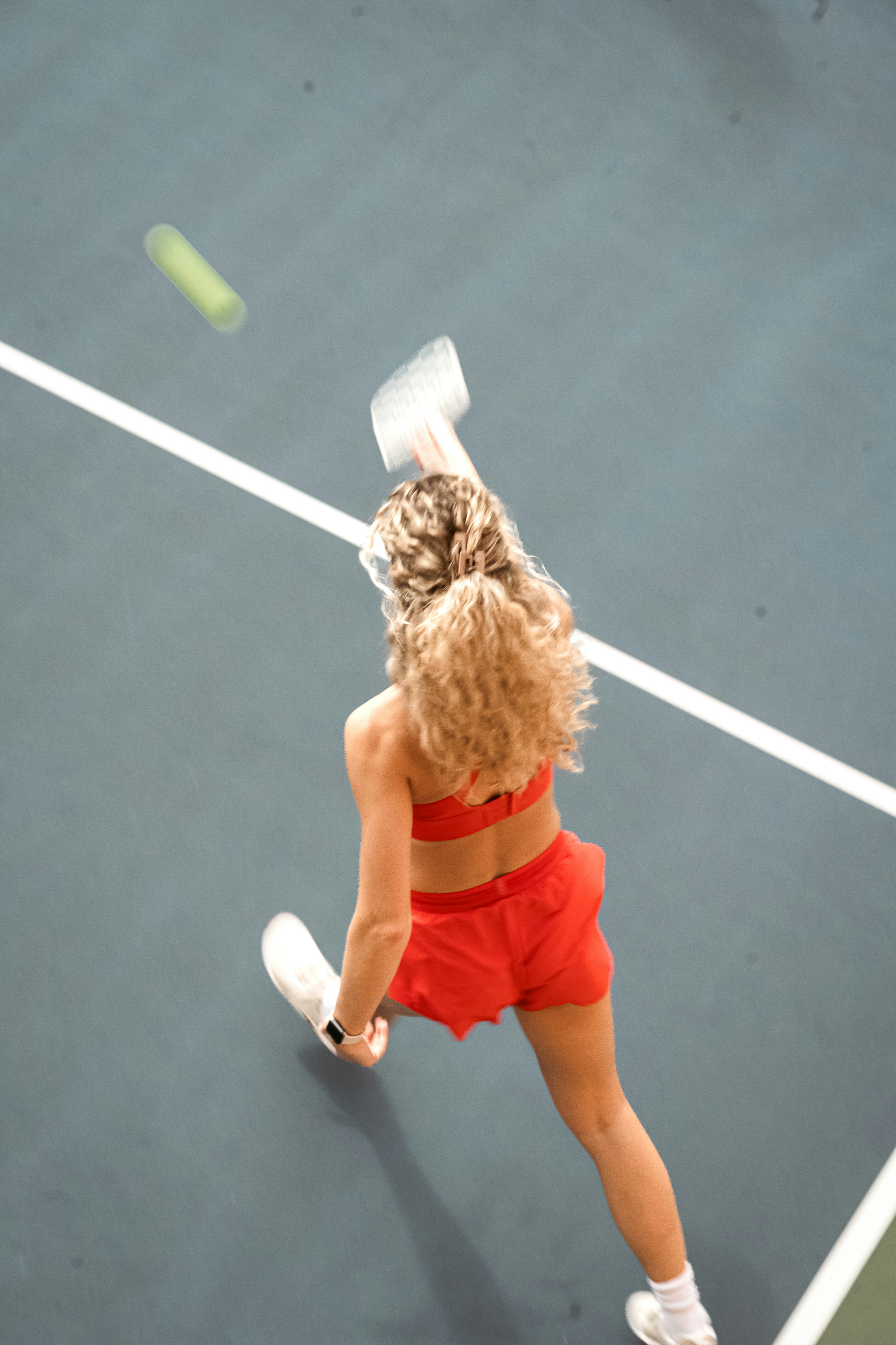 Woman in red playing tennis on court