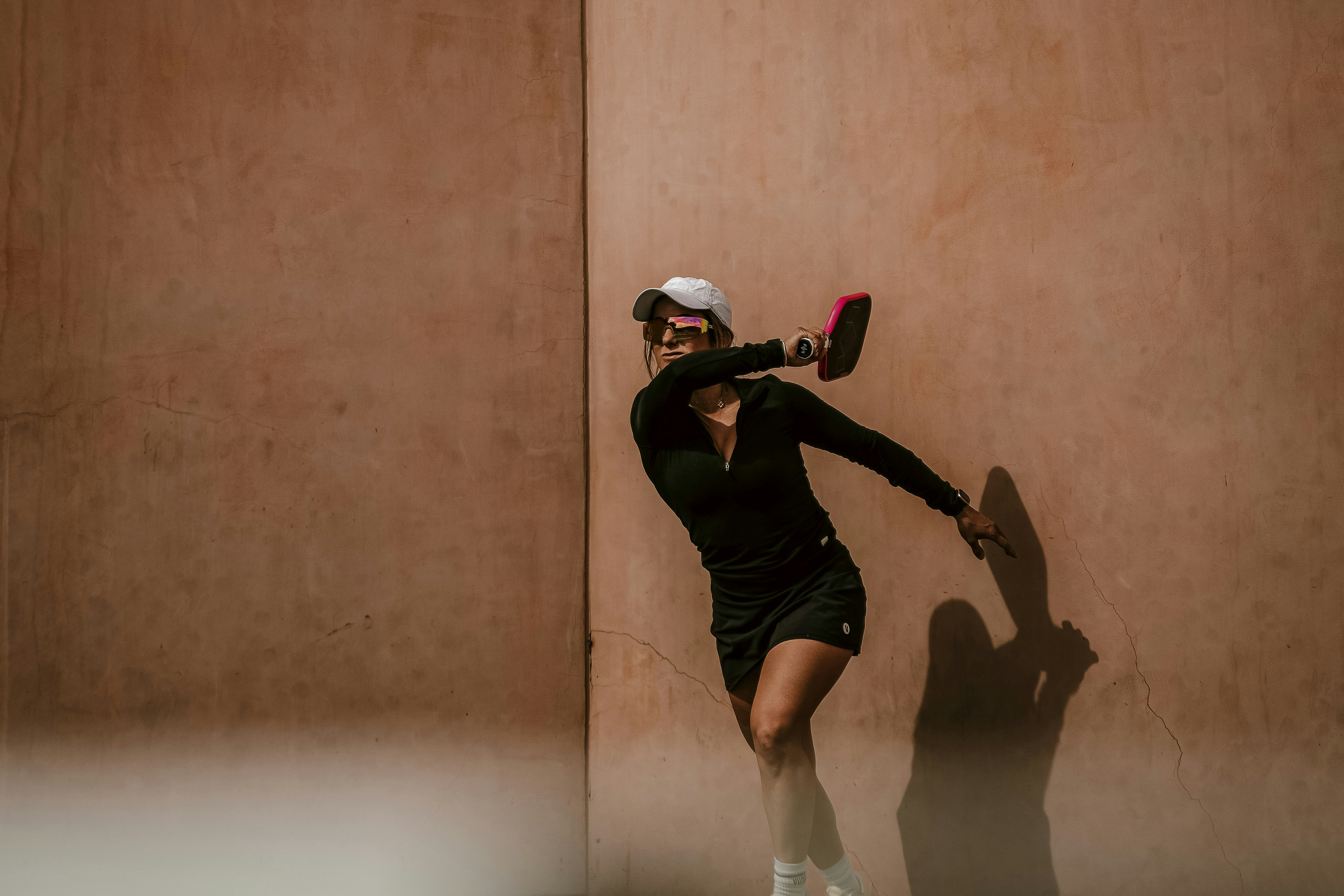 Woman in athletic wear swinging a tennis racket