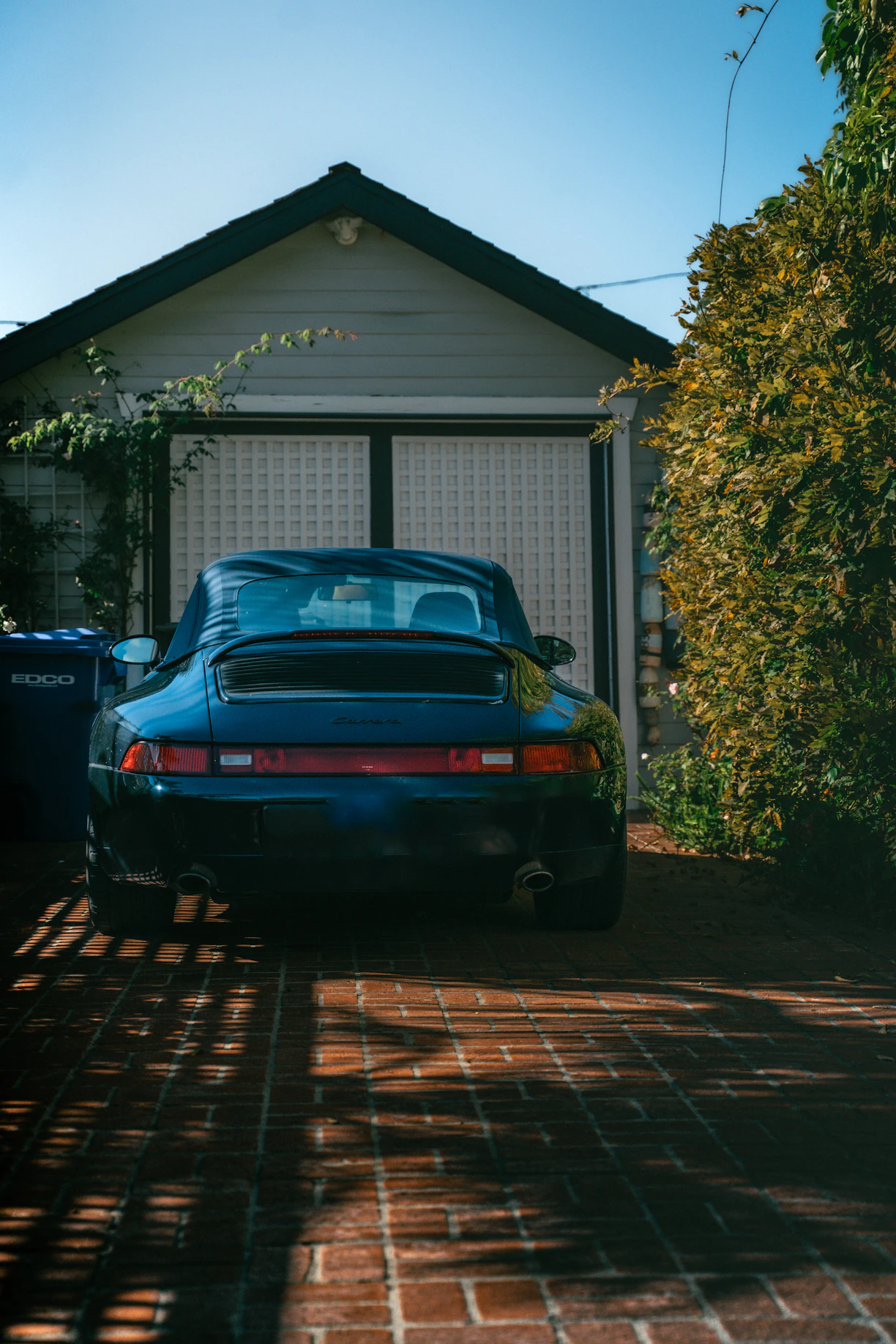 Dark blue sports car parked in front of garage