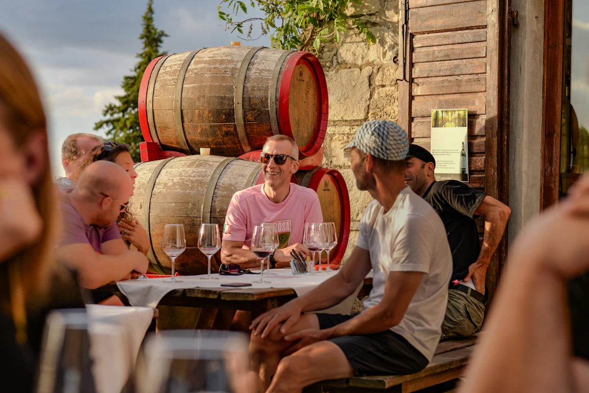 A group tasting wine among the barrels of an estate