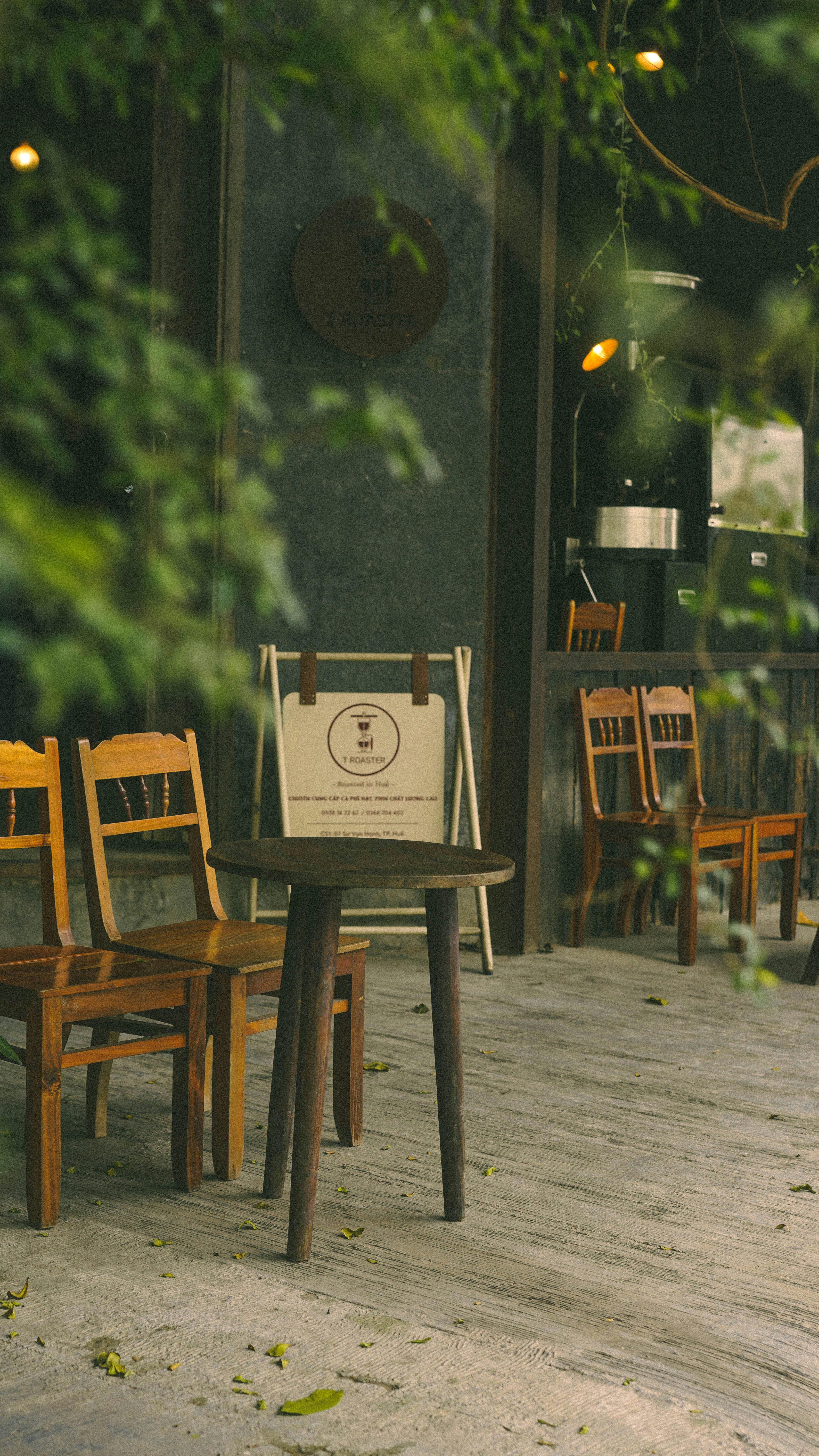 Wooden chairs and table outside a cafe with a sign
