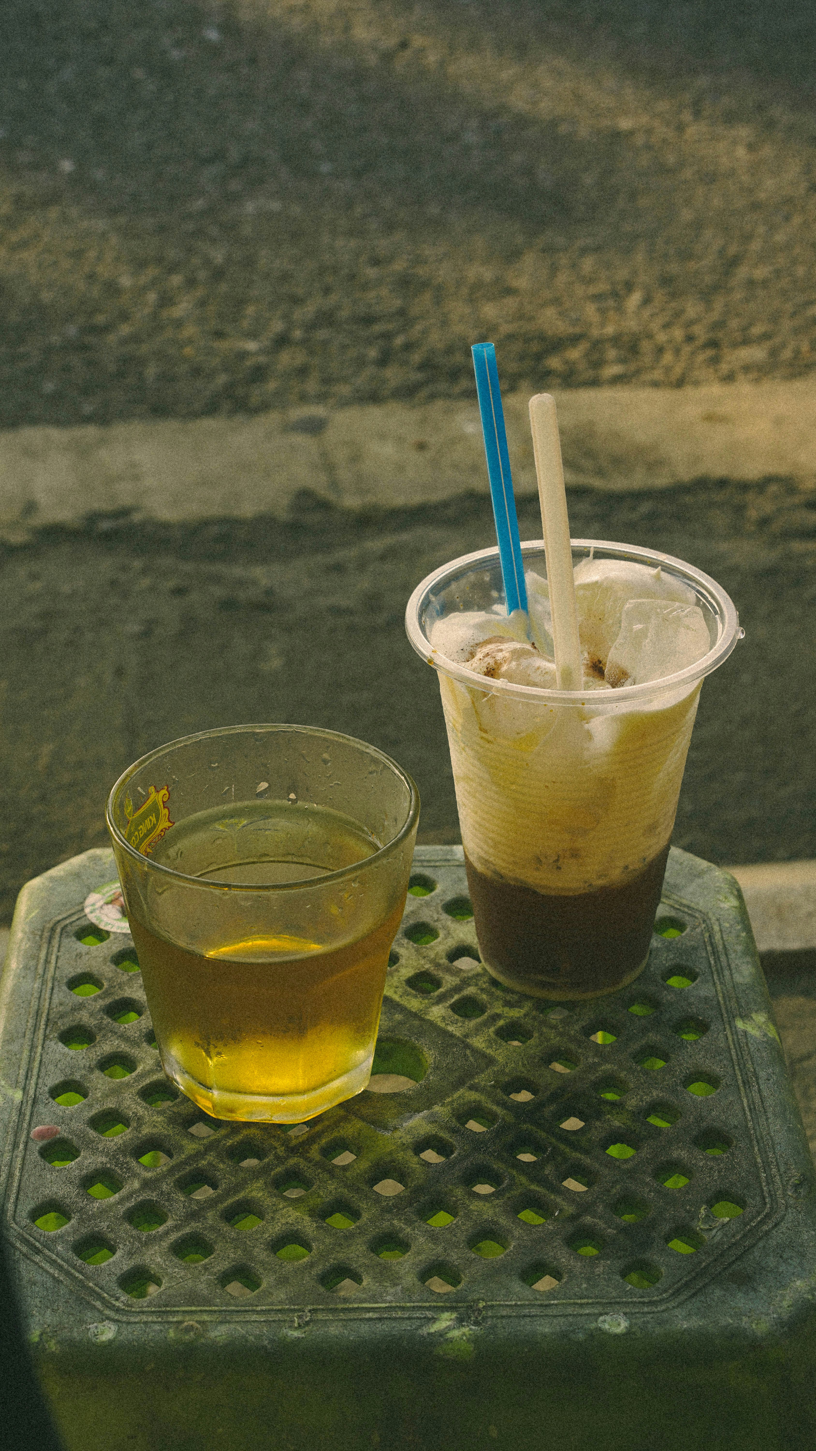 Dos copas en un taburete de plástico verde.