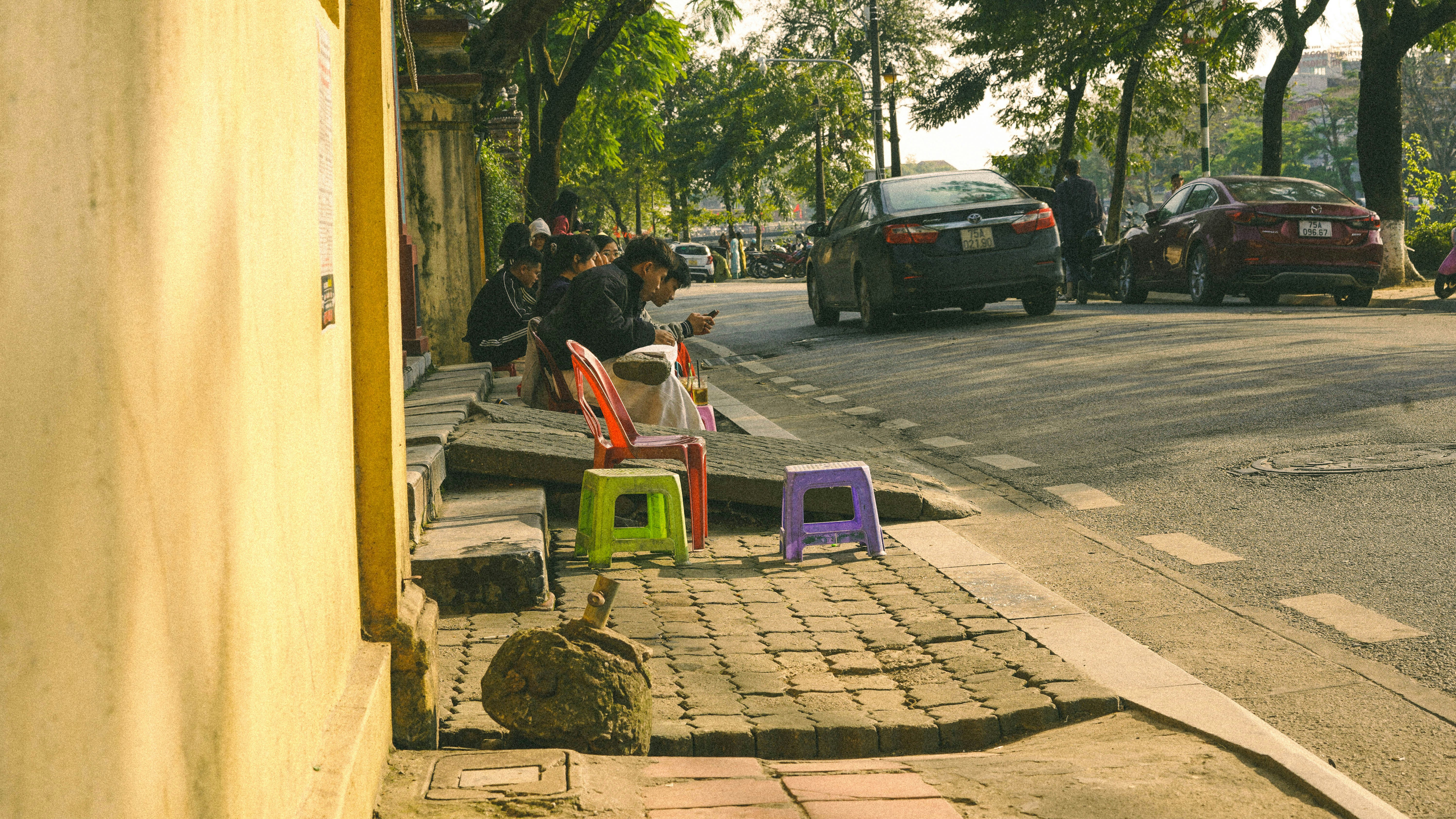 Menschen, die auf Stühlen an einer Straße sitzen
