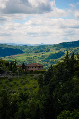 A house sits on a hill overlooking rolling green landscape