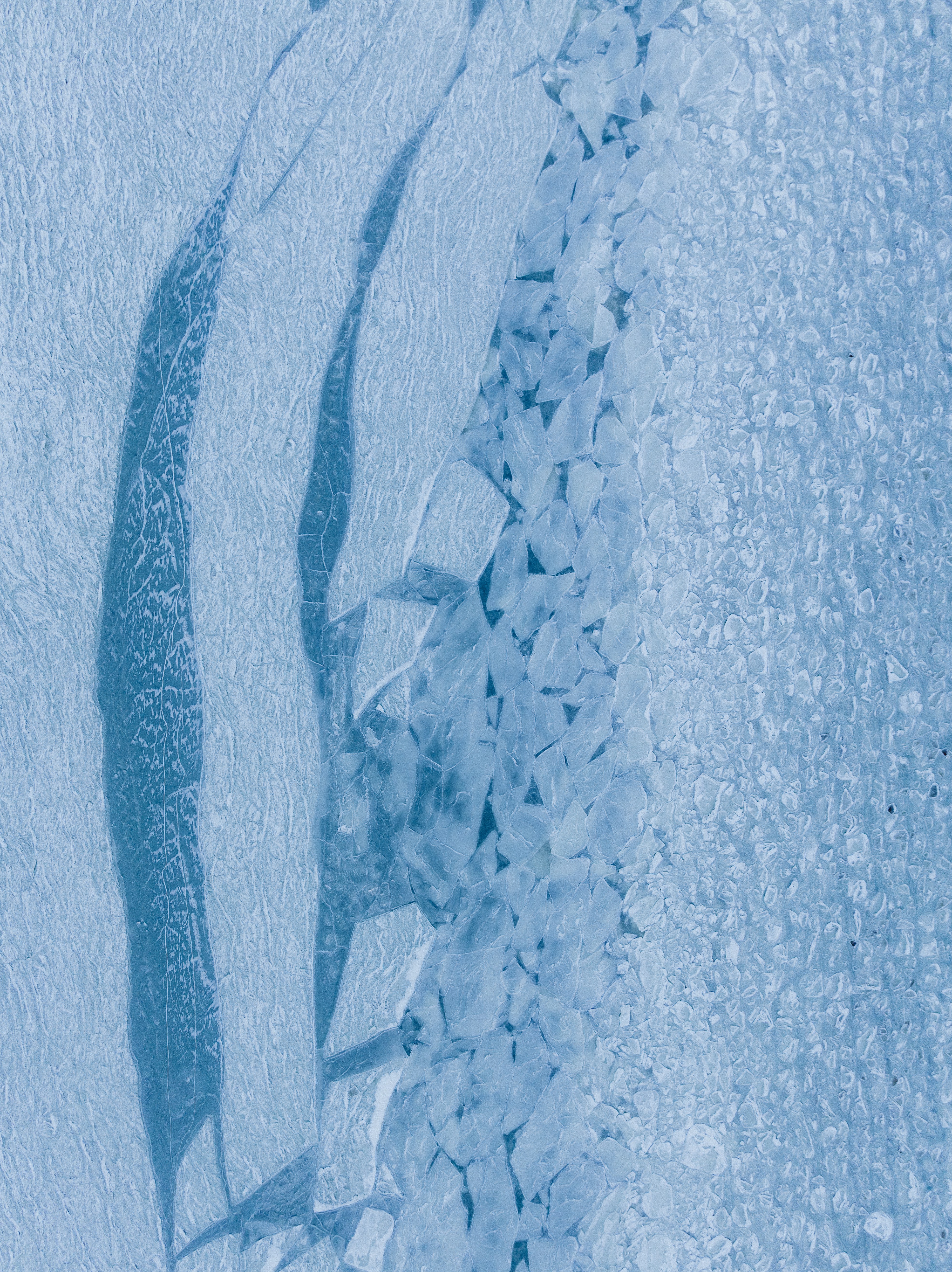 Cracked ice surface with blue shadows and textures