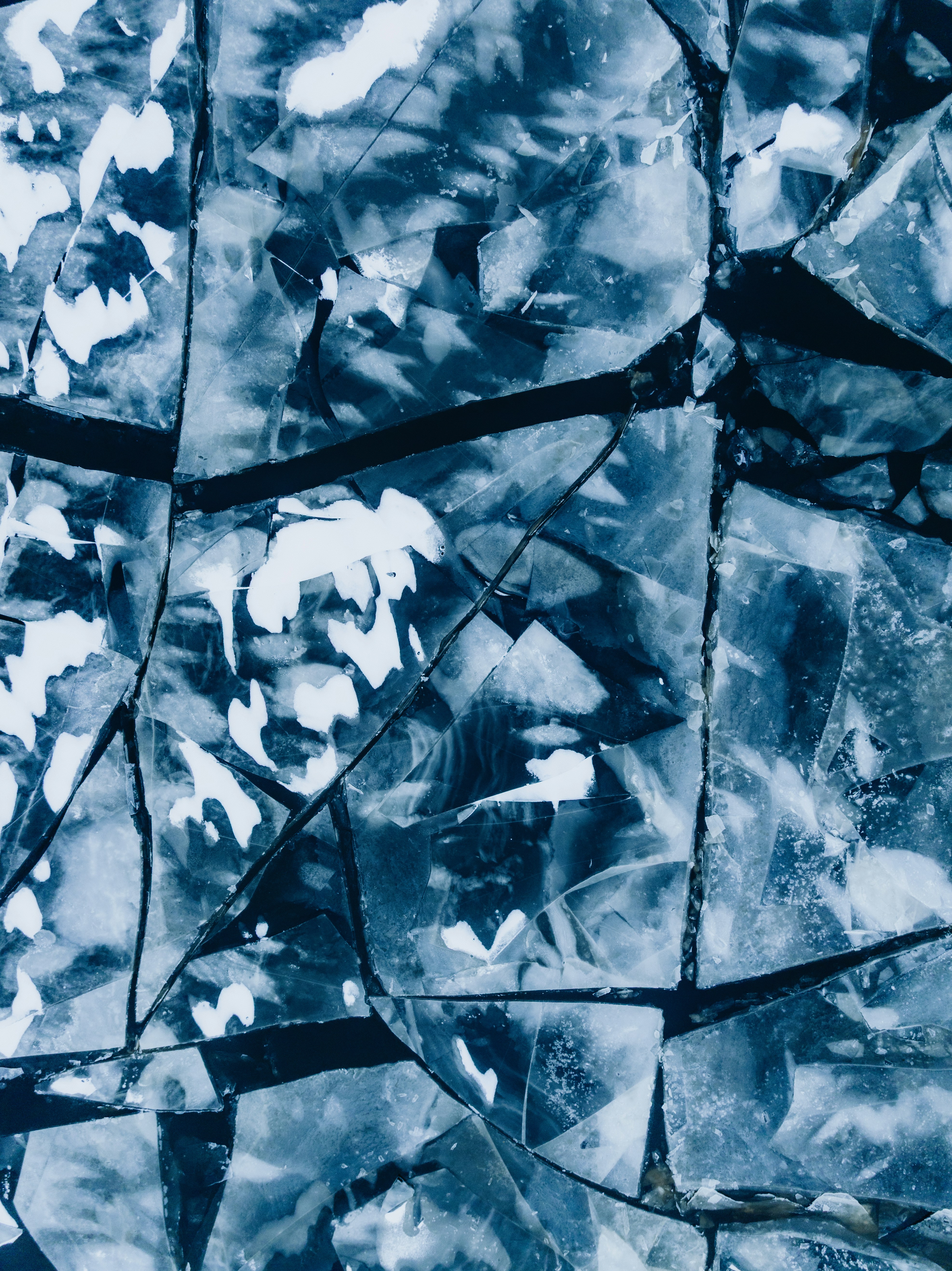 Cracked ice with white snow patterns.