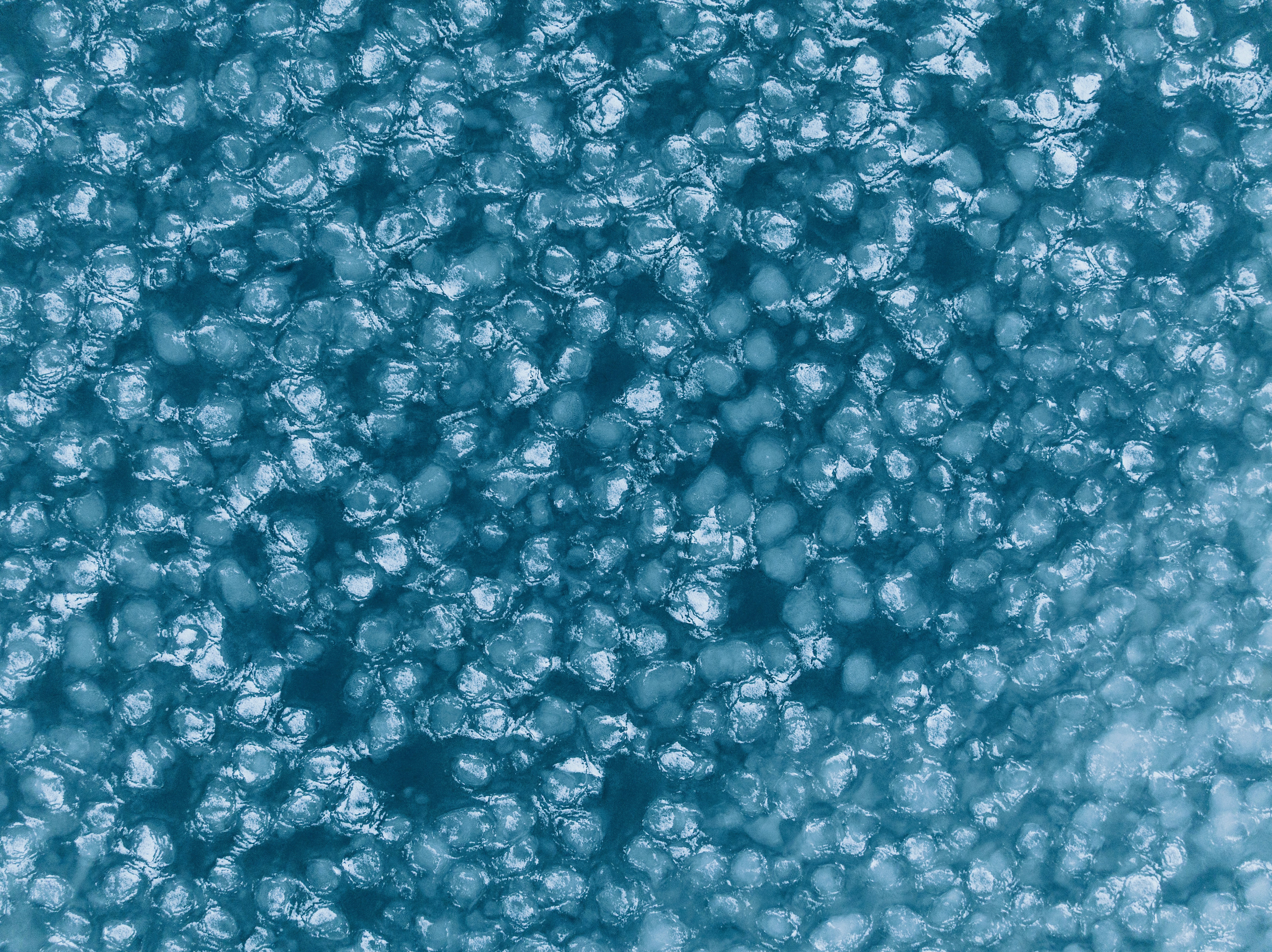 Abstract pattern of small, circular, textured shapes in blue.