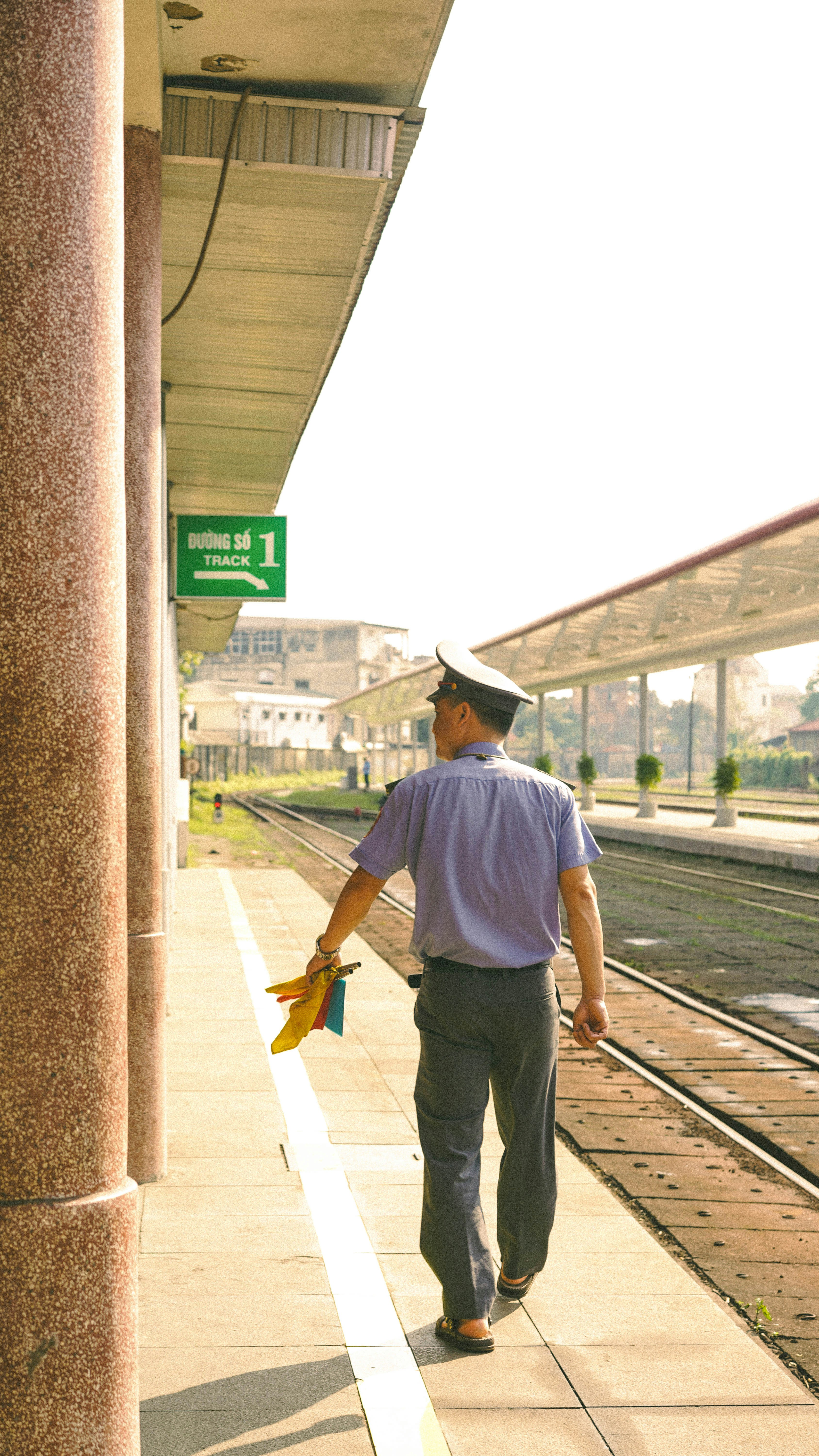 Train conductor walking on platform with flags