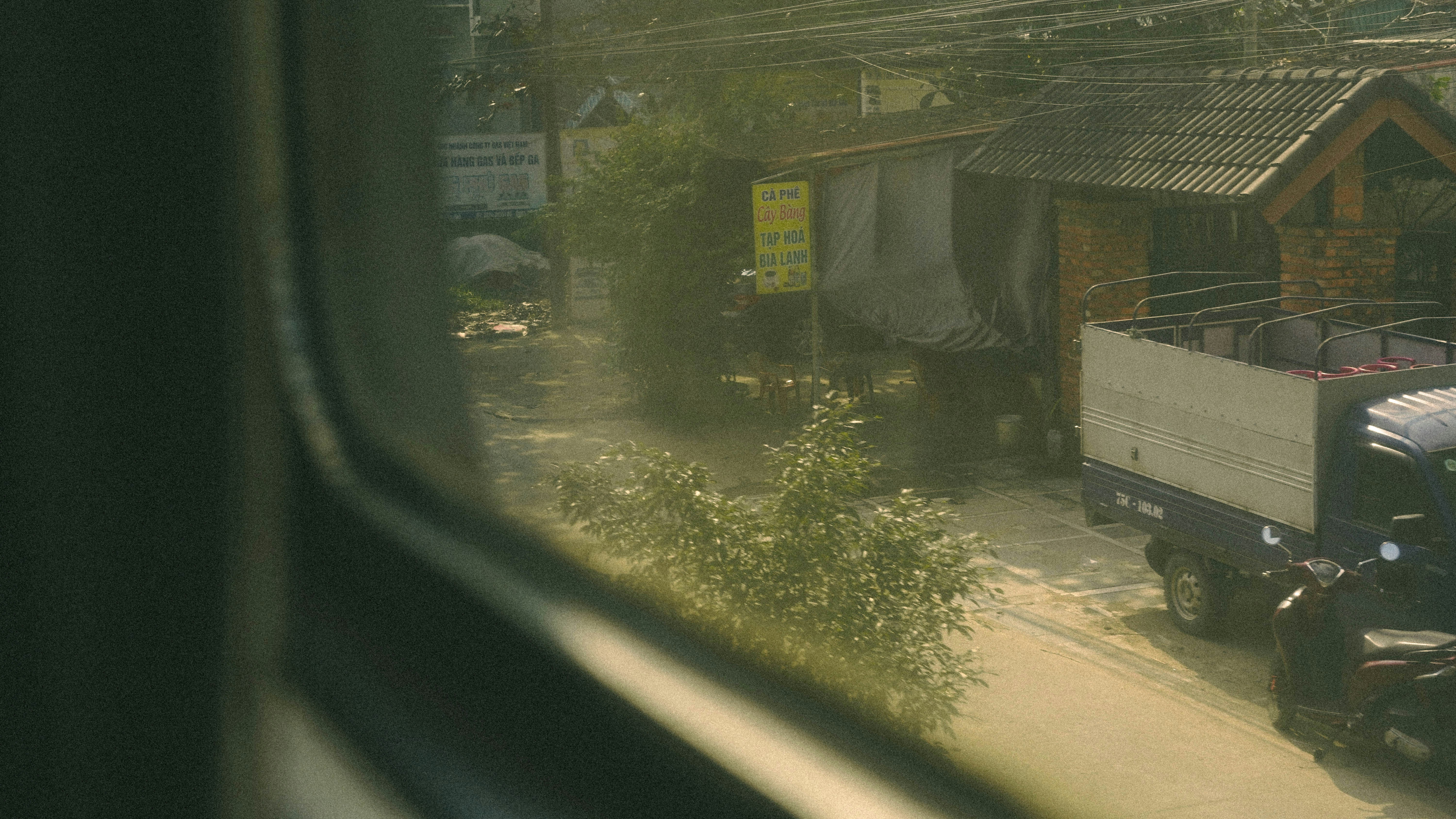 Truck parked on a dusty road near houses.
