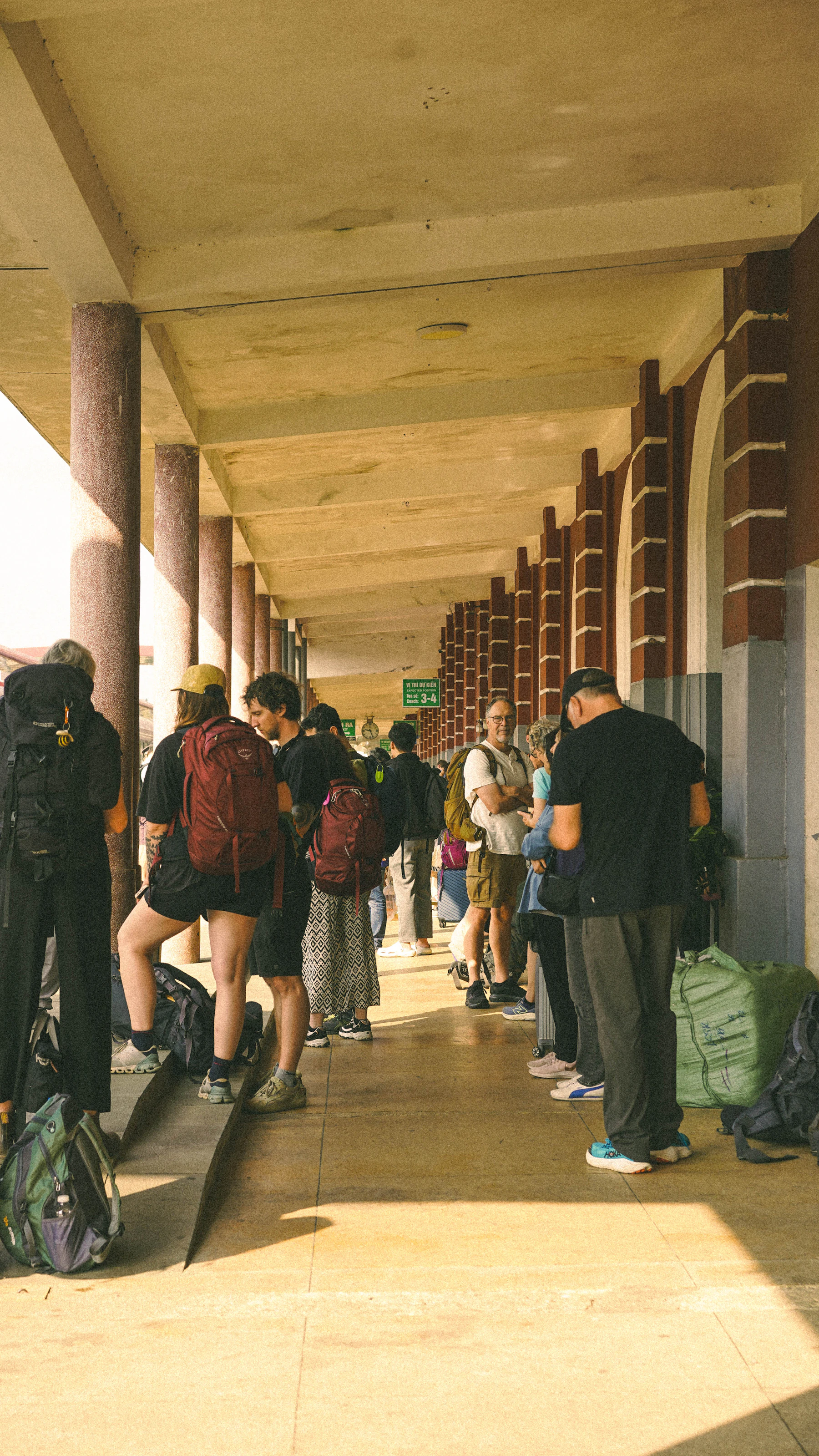 Travellers with backpacks waiting at a railway station in Hue, Vietnam