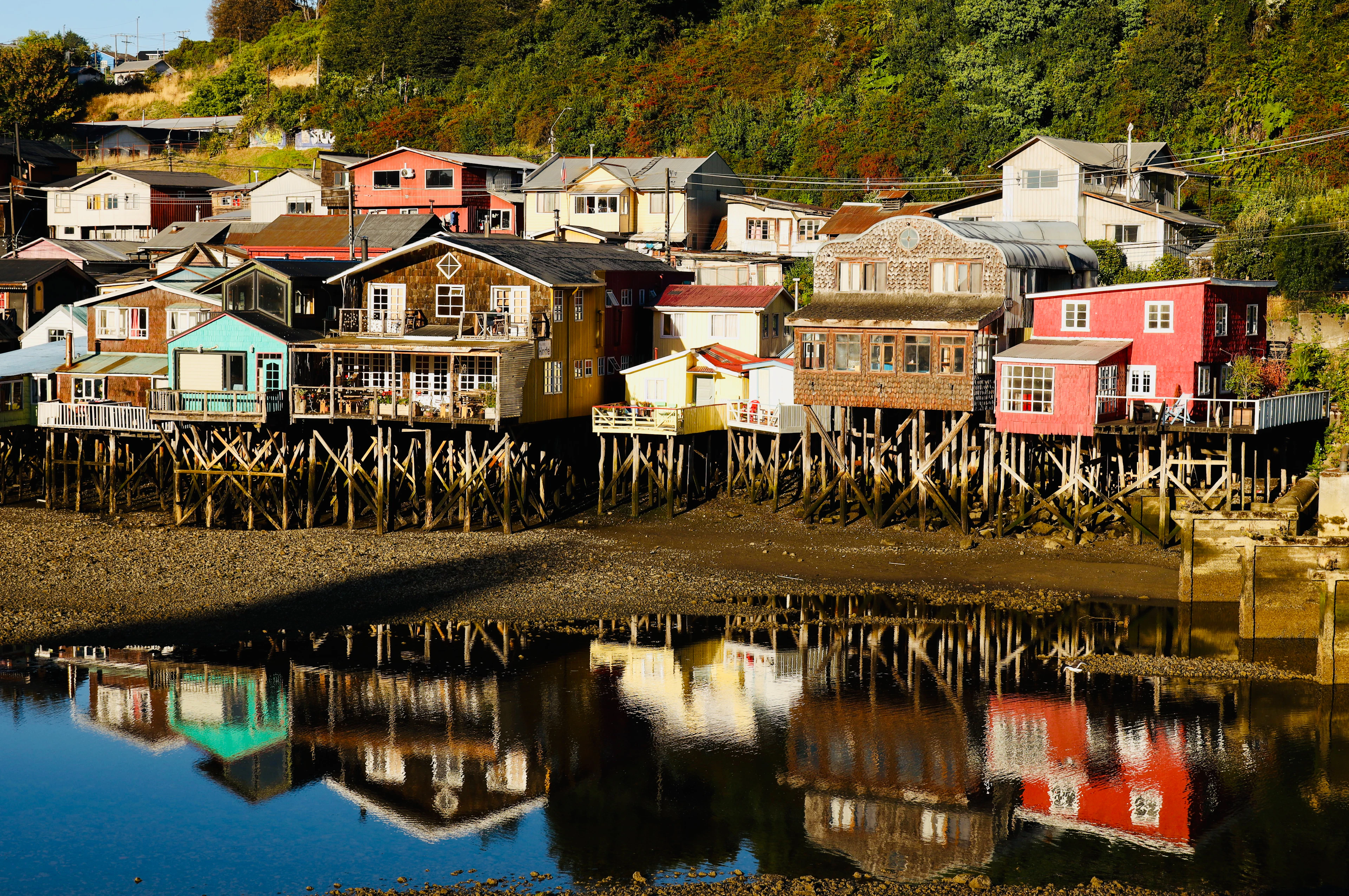 Colourful stilt houses reflected in still water in Castro, Chiloé, Chile