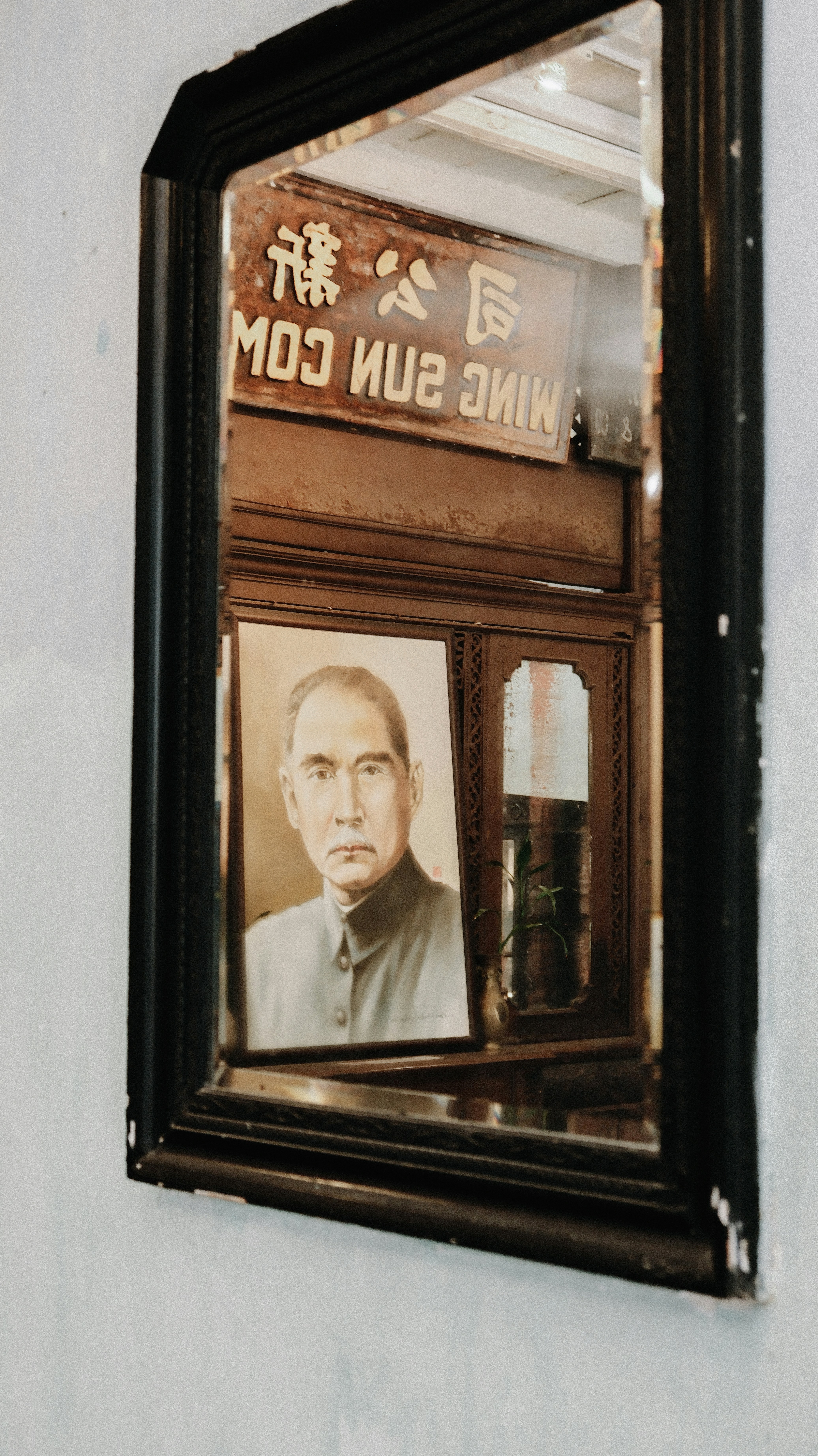 Portrait of a man reflected in an ornate mirror.