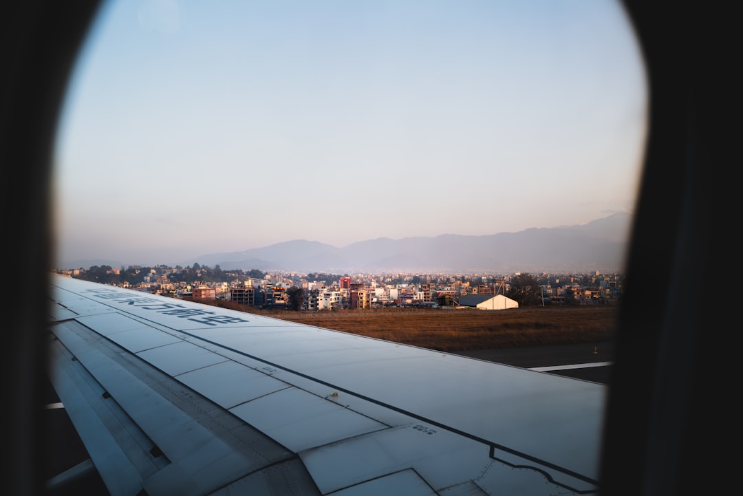 Airplane wing over a city at sunset