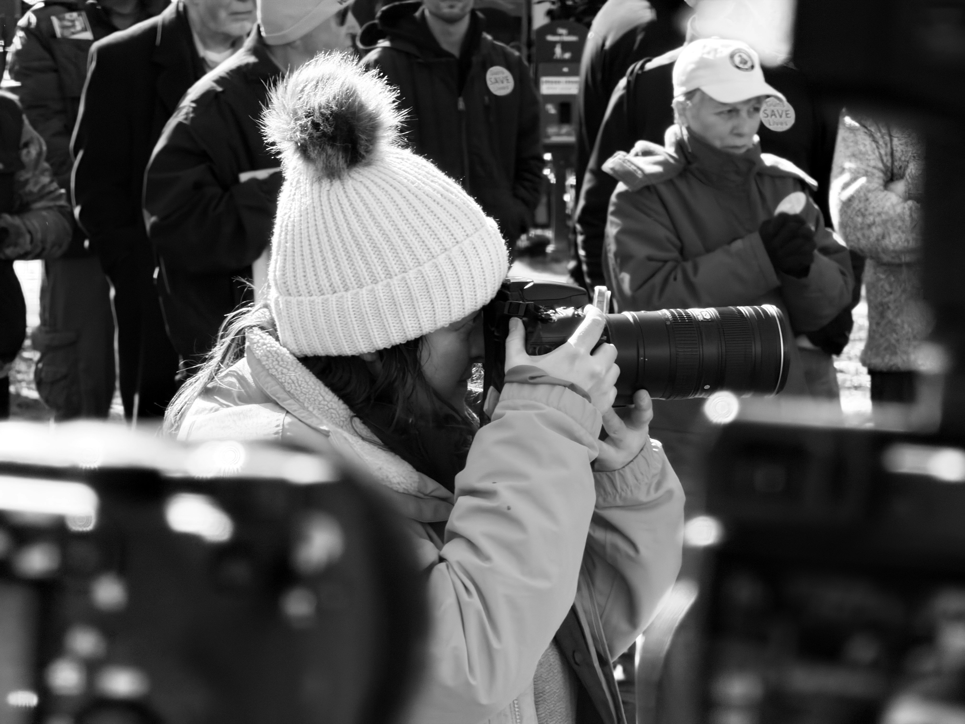 Woman in beanie taking photos with large camera