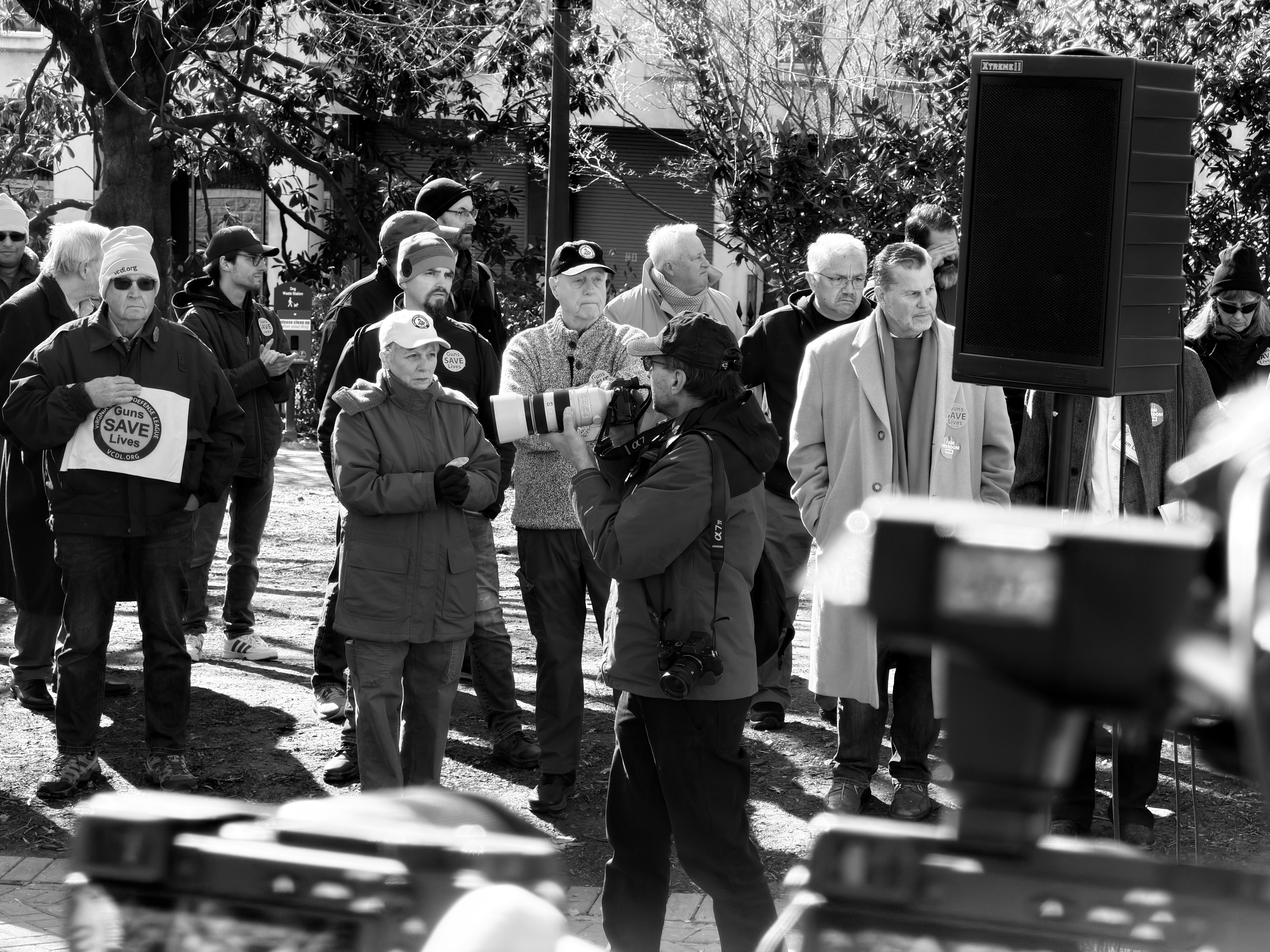 A crowd of people gathered outdoors with a cameraman.