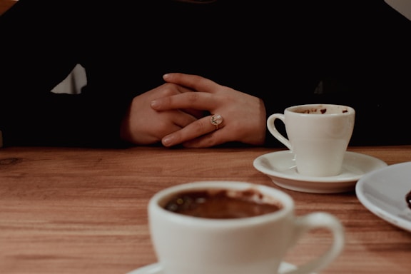 Two cups of coffee on a wooden table.
