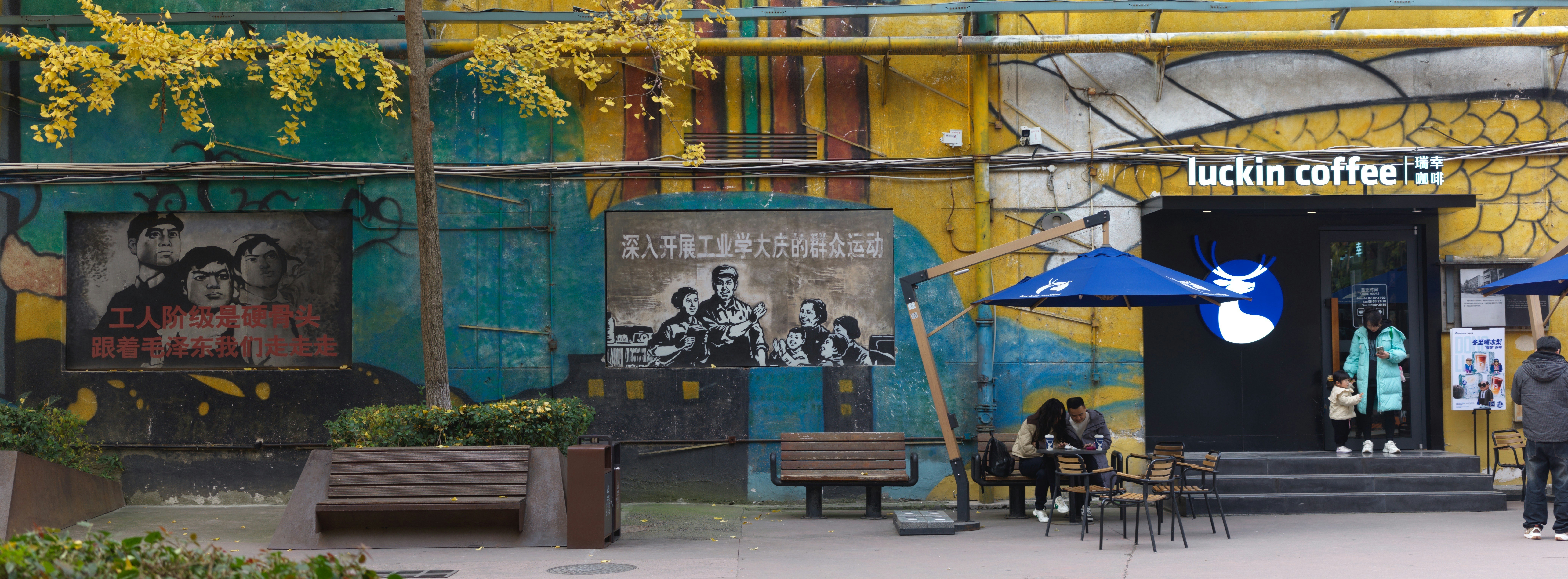 A coffee shop with colorful murals and outdoor seating