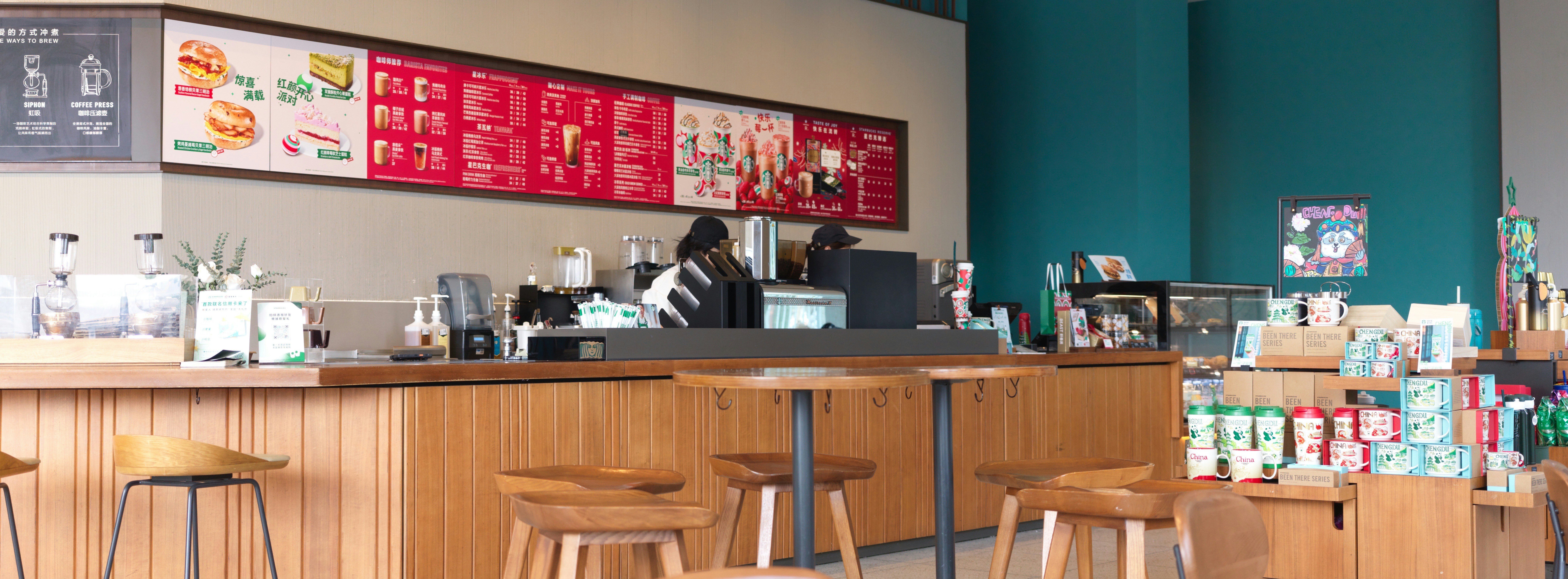 Baristas working behind a counter at a coffee shop.