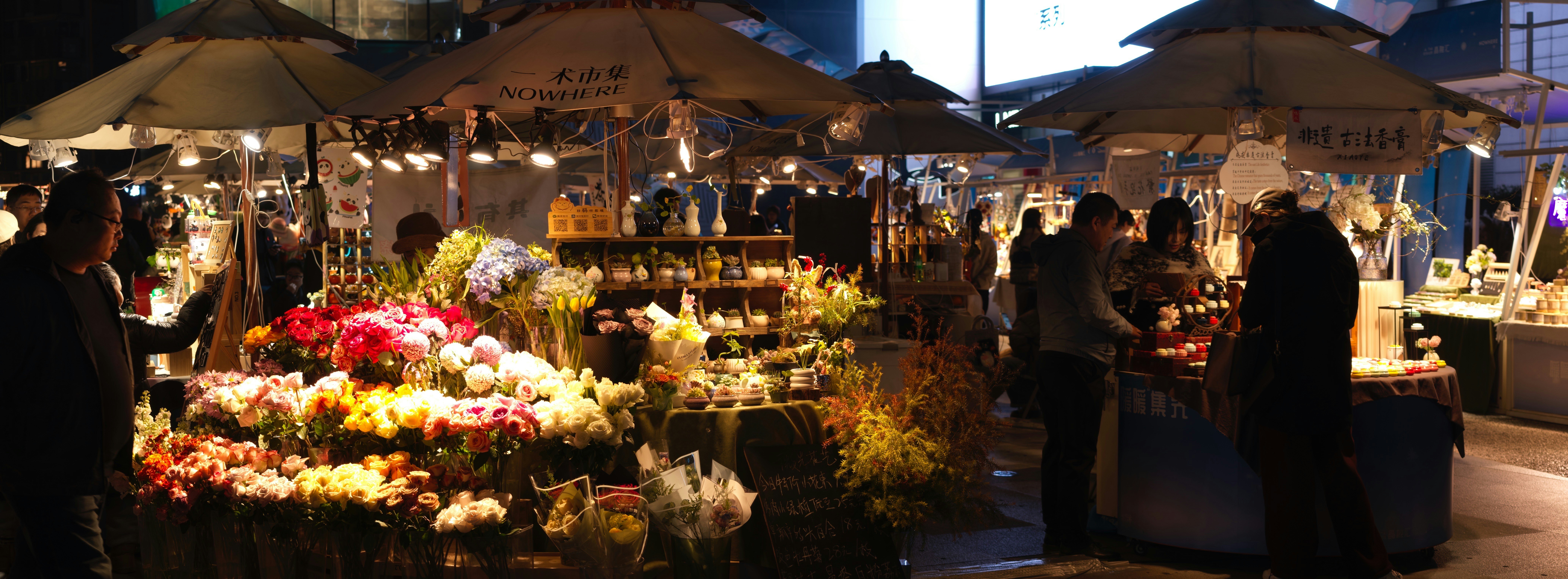 People browsing flowers at a nighttime market