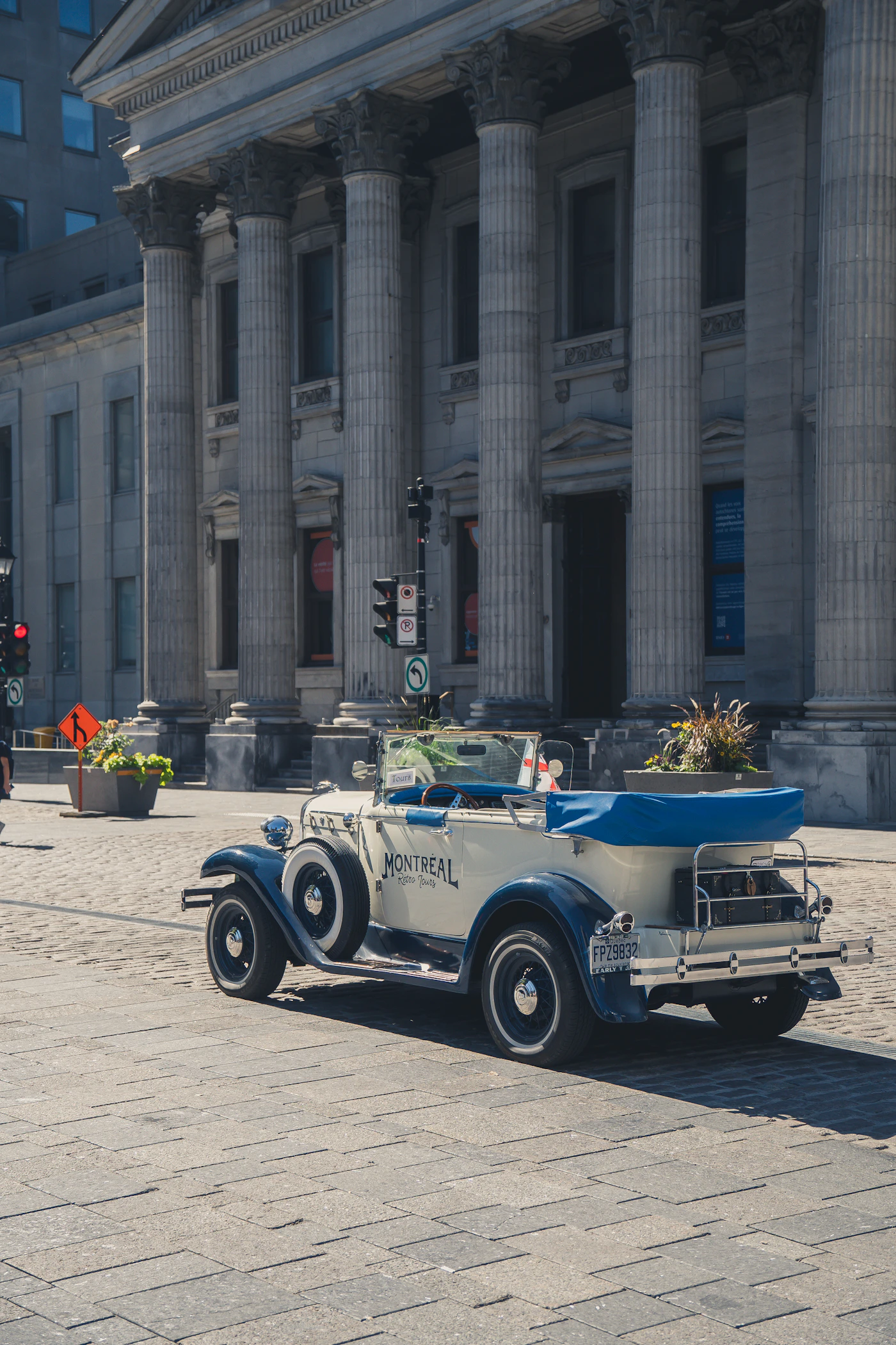 An Old Montreal cobblestone street lined with grey-stone heritage buildings in warm evening light