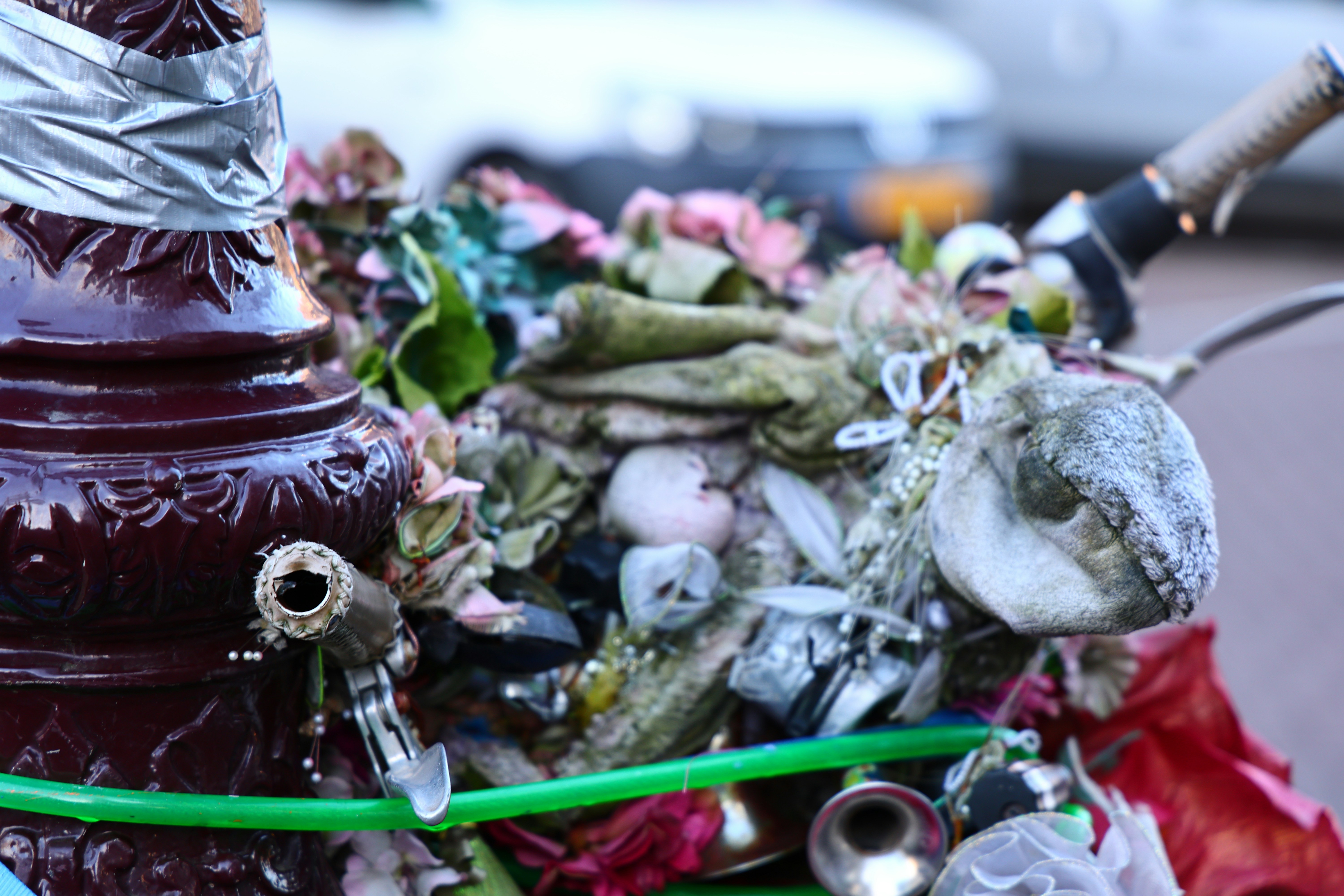 A close-up of a decorated pole with various objects attached.