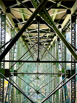 Intricate metal framework of a large green bridge