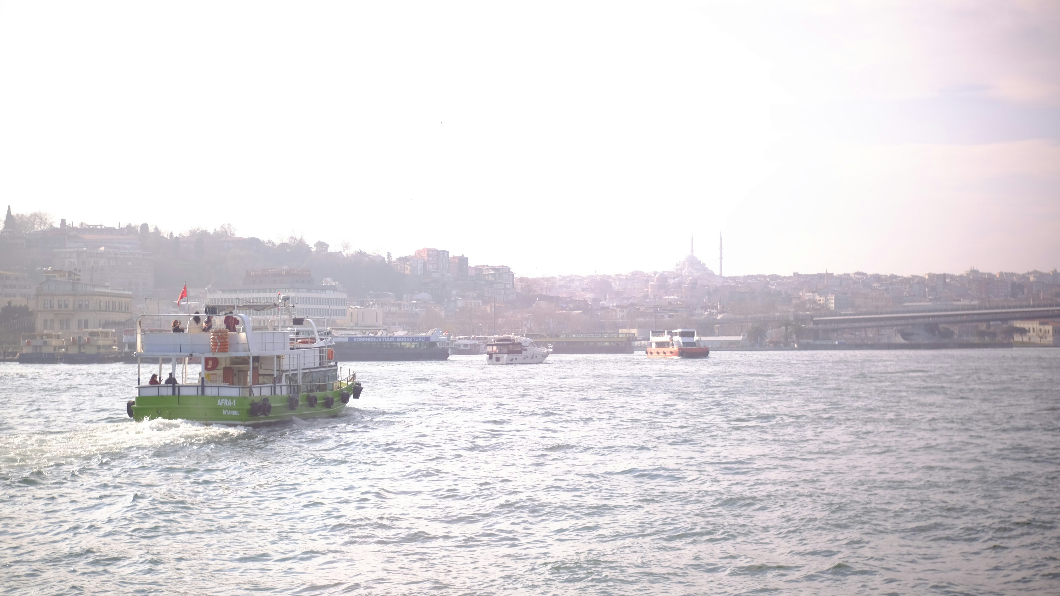 Boats on the water with a city skyline.