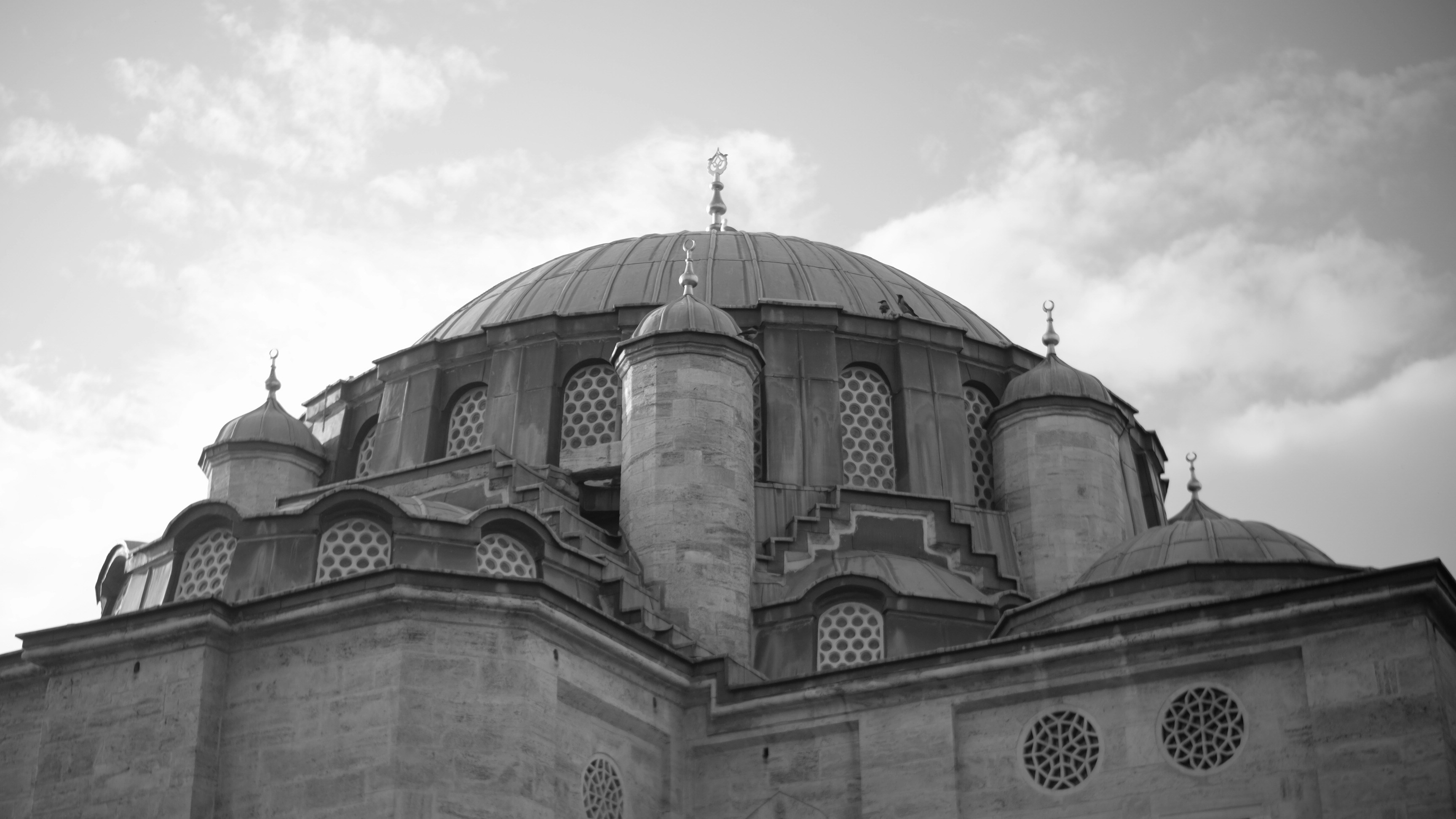 A large dome of a mosque against a cloudy sky