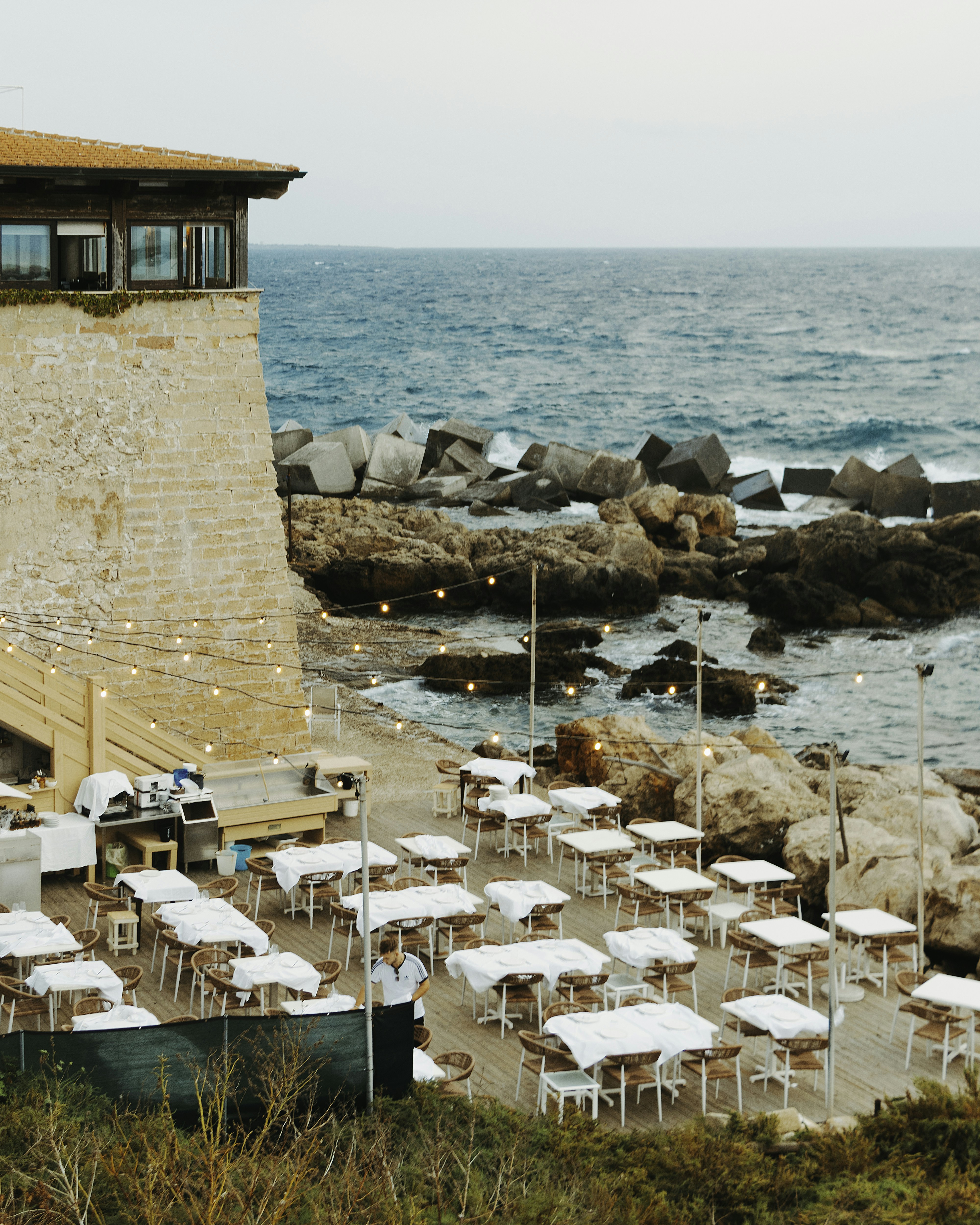 Restaurants im Freien, gedeckt an der felsigen Meeresküste.