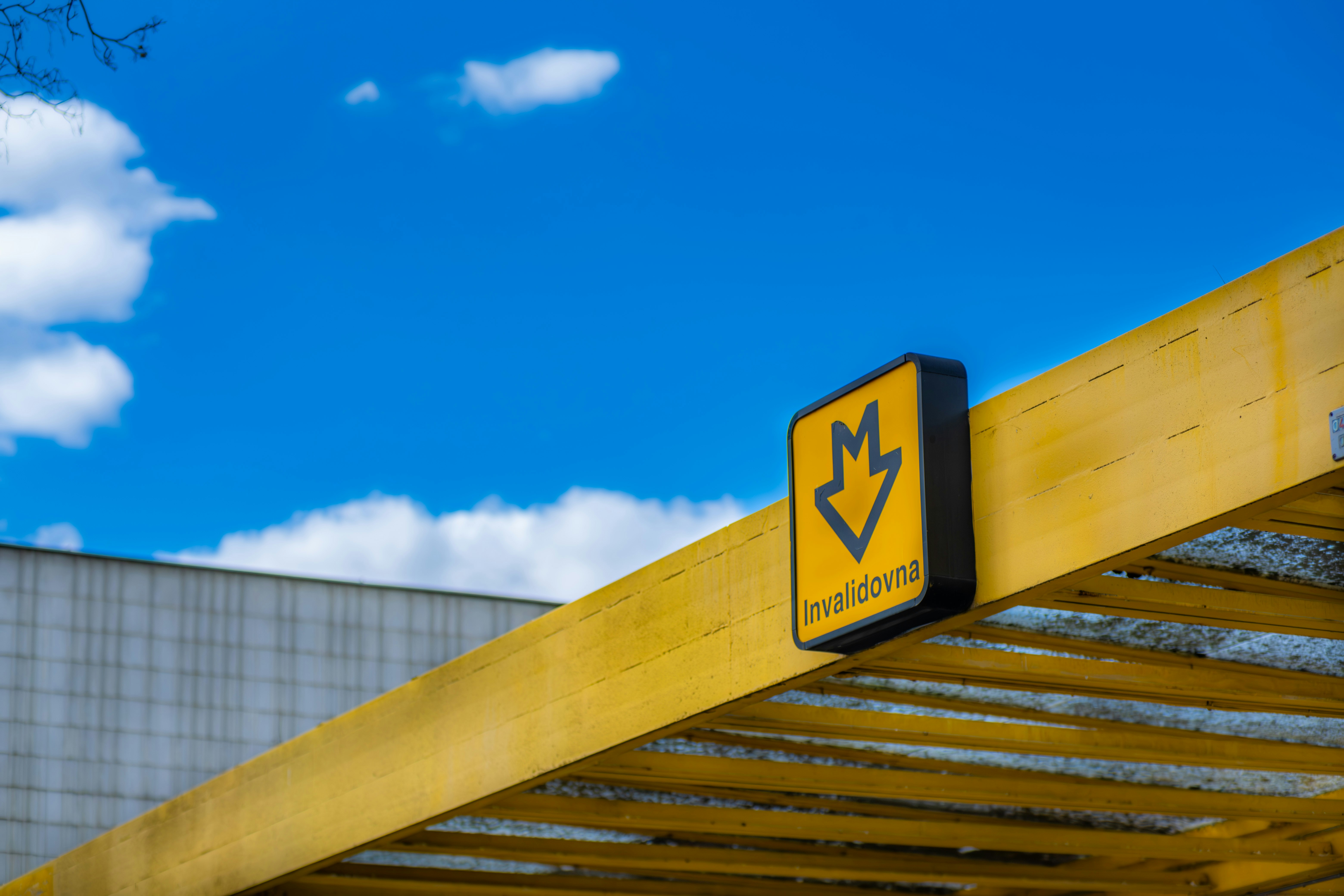 Placa amarela com seta para baixo sob o céu azul