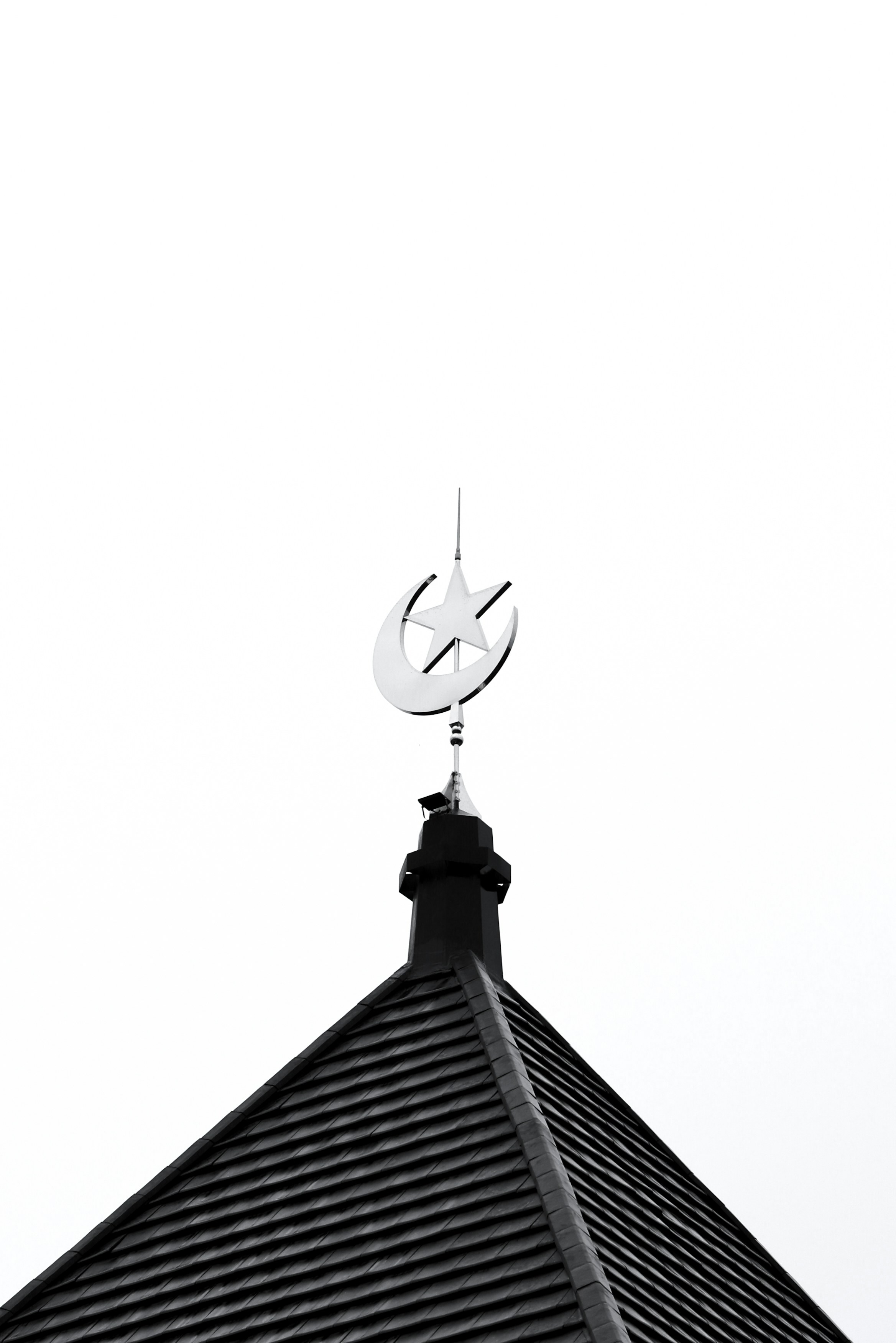 Crescent moon and star atop a dark roof