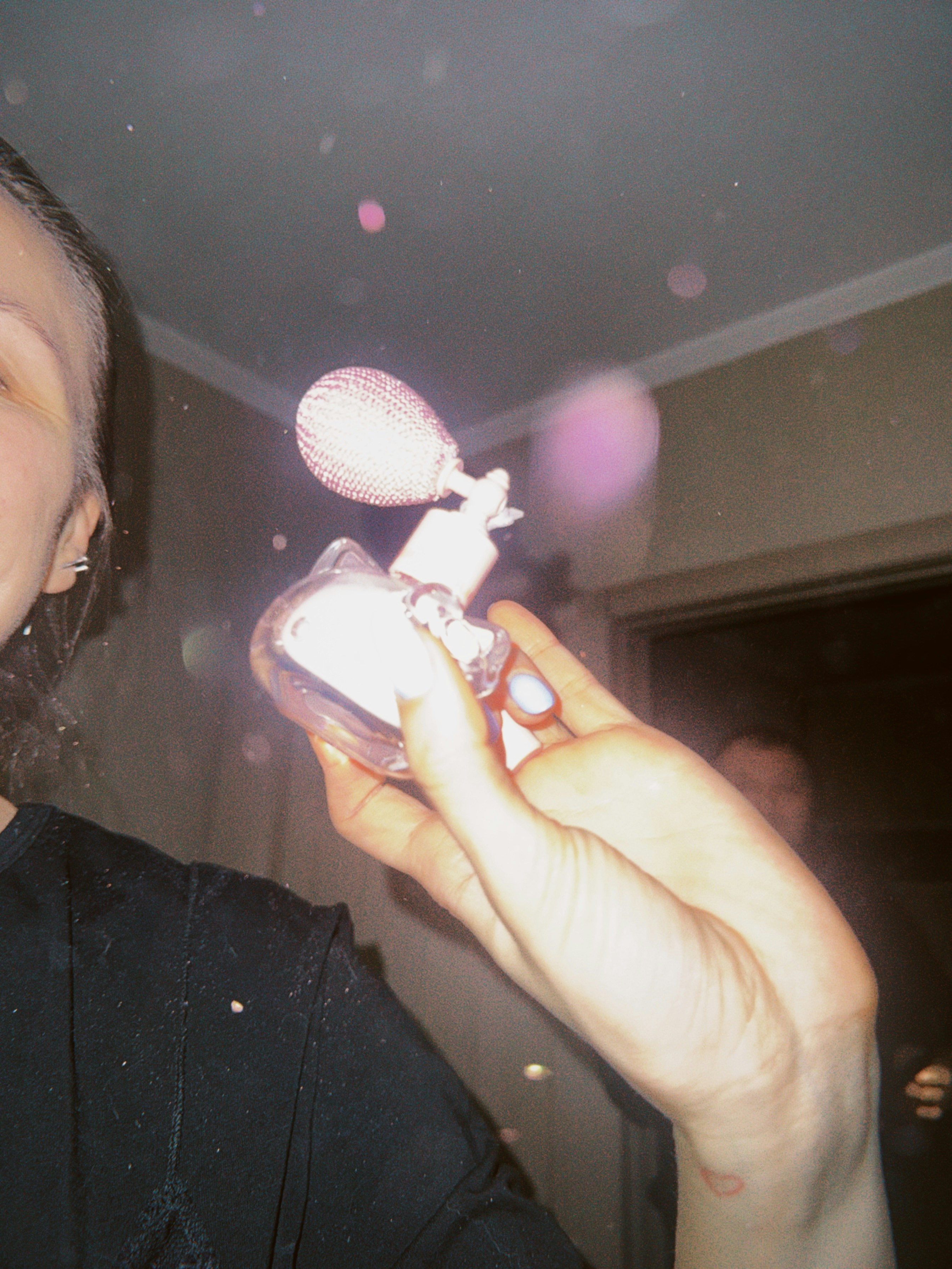 Ich hielt einen Vintage-Parfüm-Zerstäuber mit rosa Nebel.