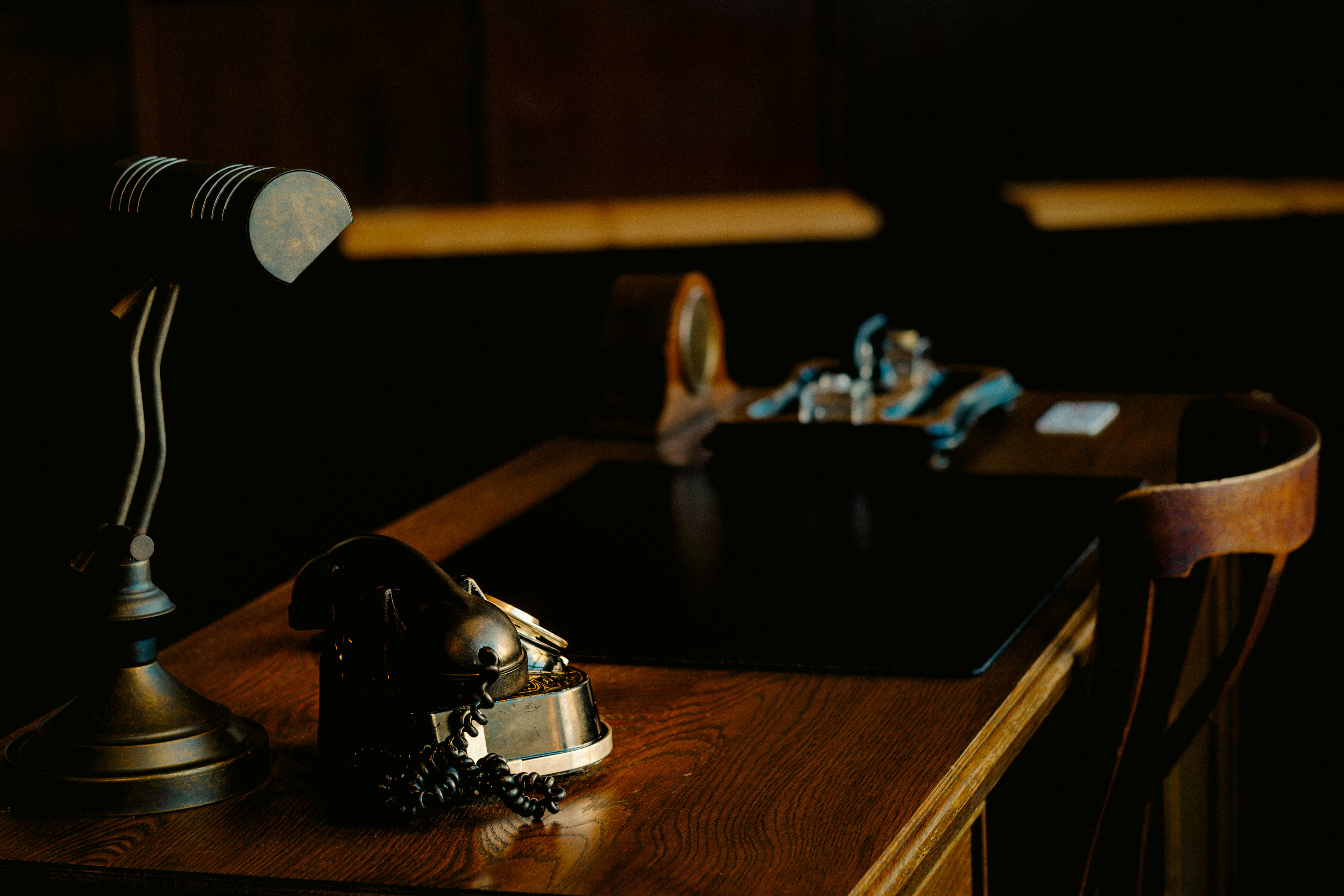 Vintage desk with lamp and ornate object.