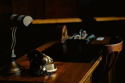 Vintage desk with lamp and ornate object.