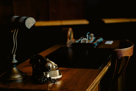 Vintage desk with lamp and ornate object.