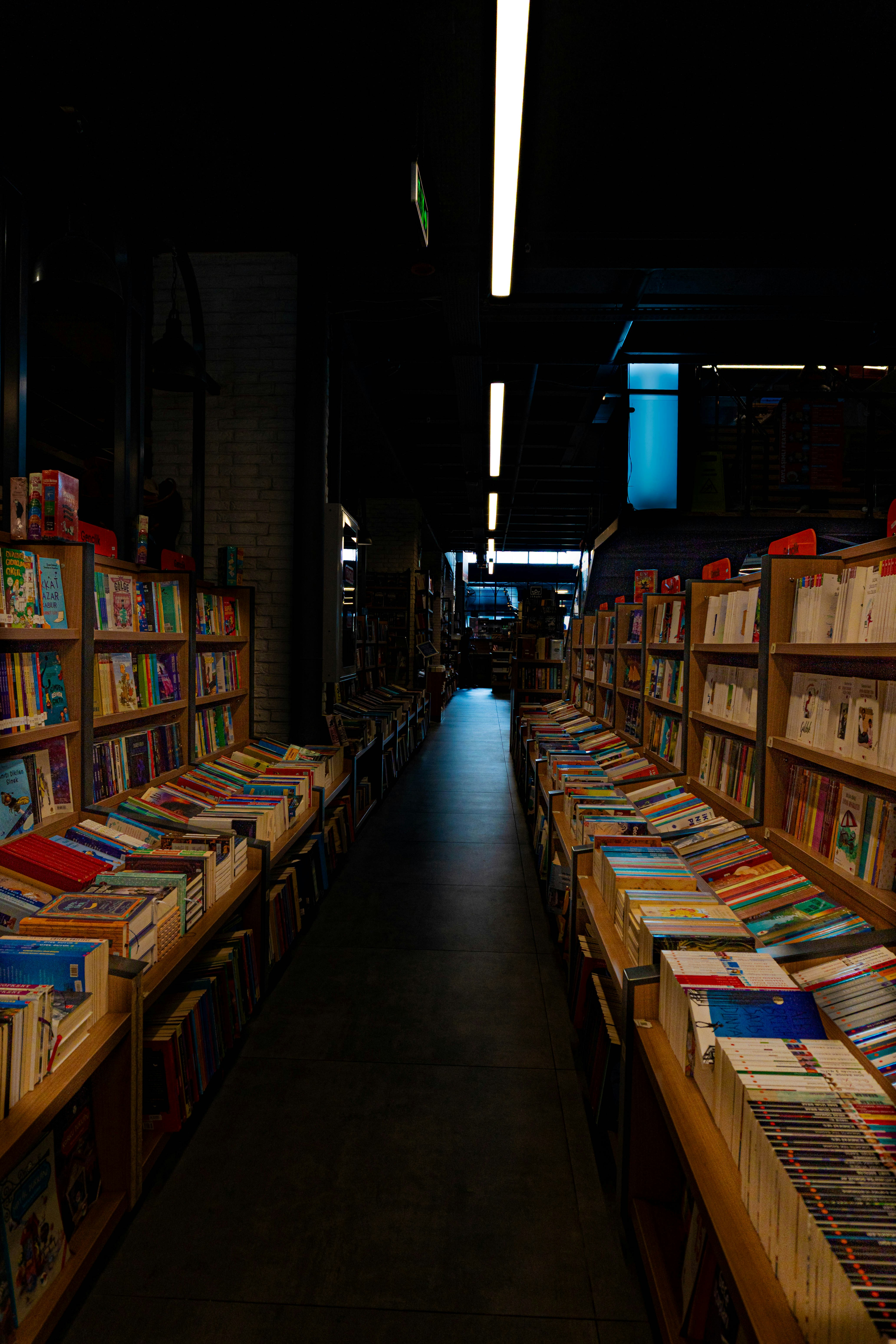 Lorong panjang yang dilapisi dengan rak buku di toko buku.