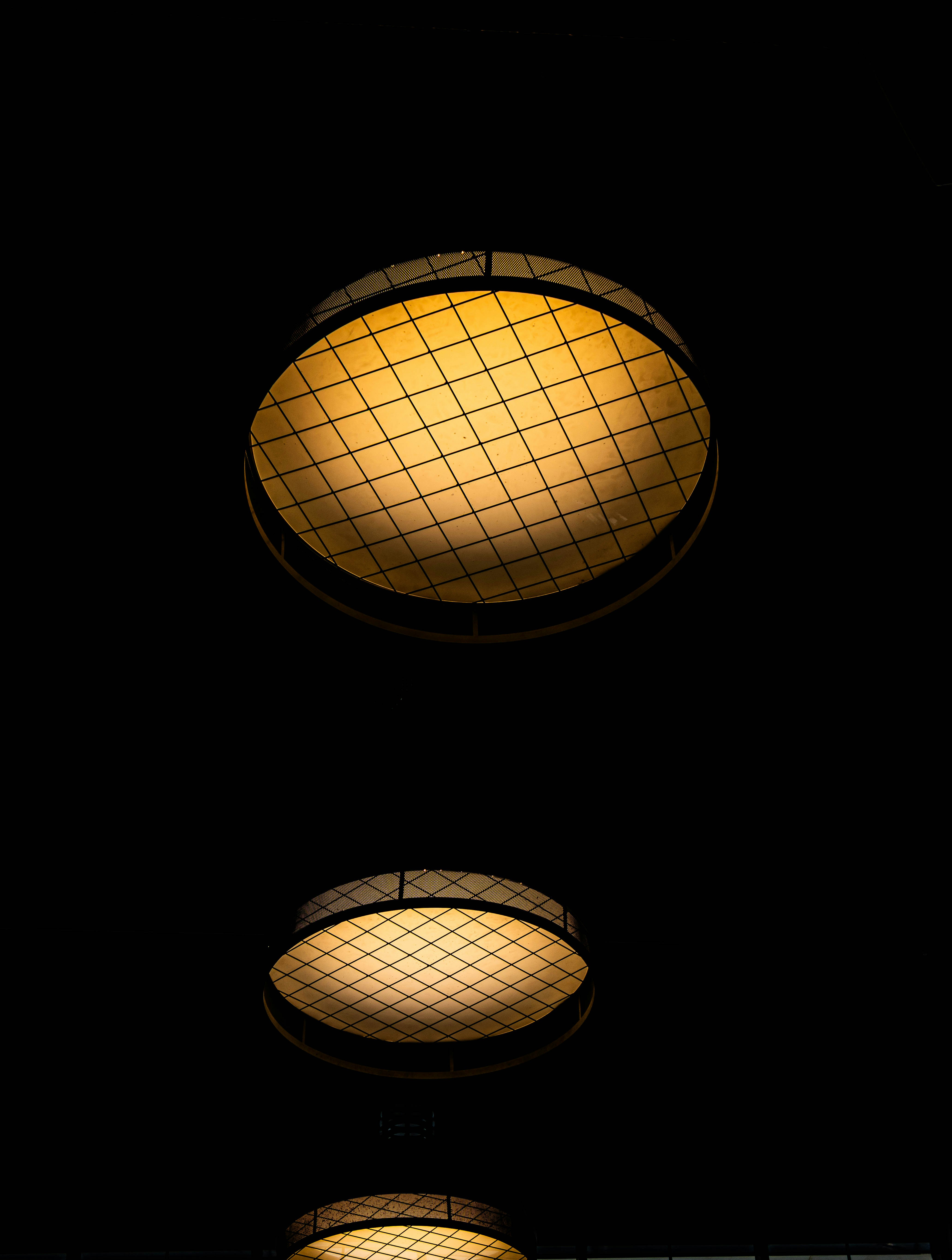 Dos luces de techo iluminadas sobre un fondo oscuro.