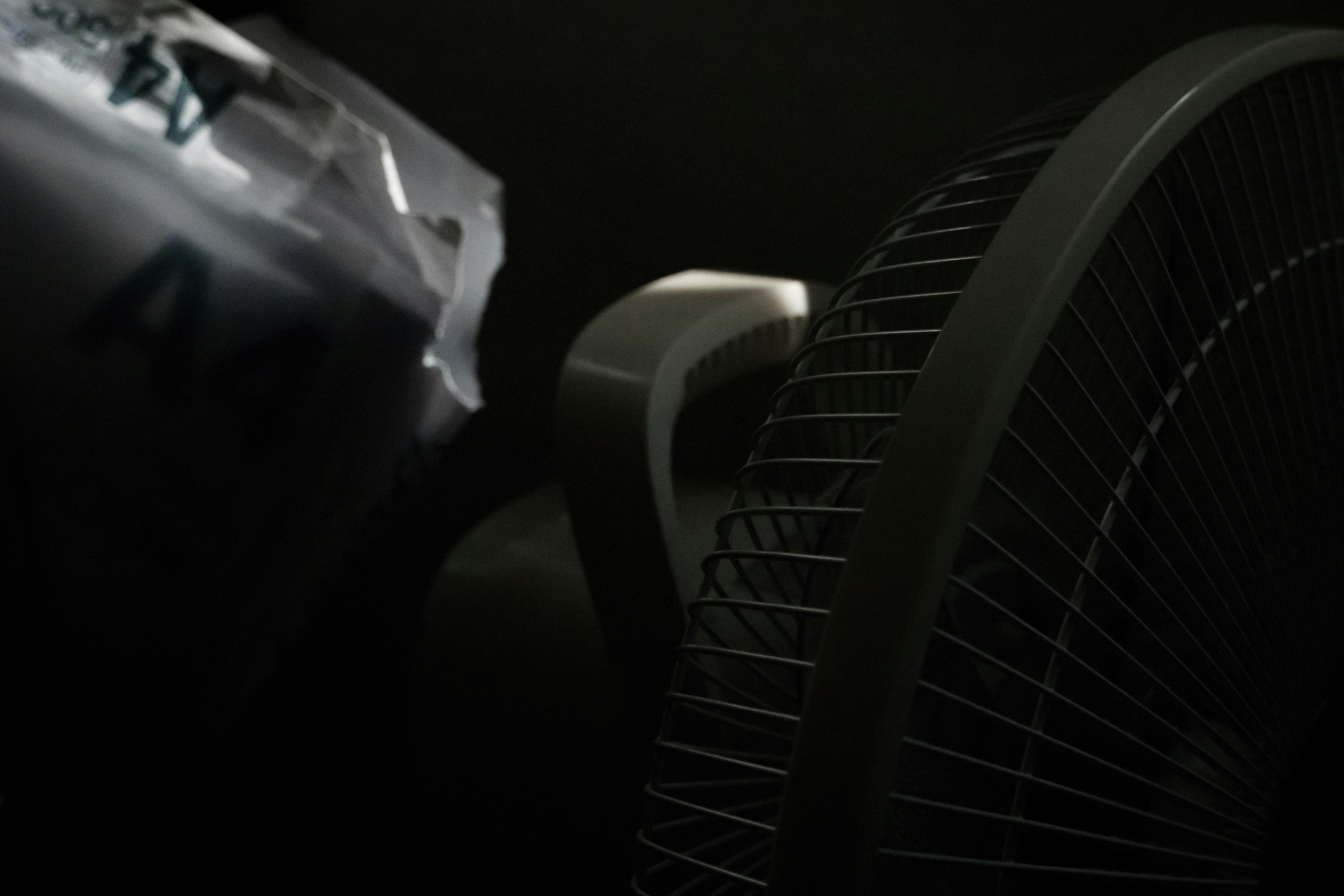 Close-up of a white fan with a dark background
