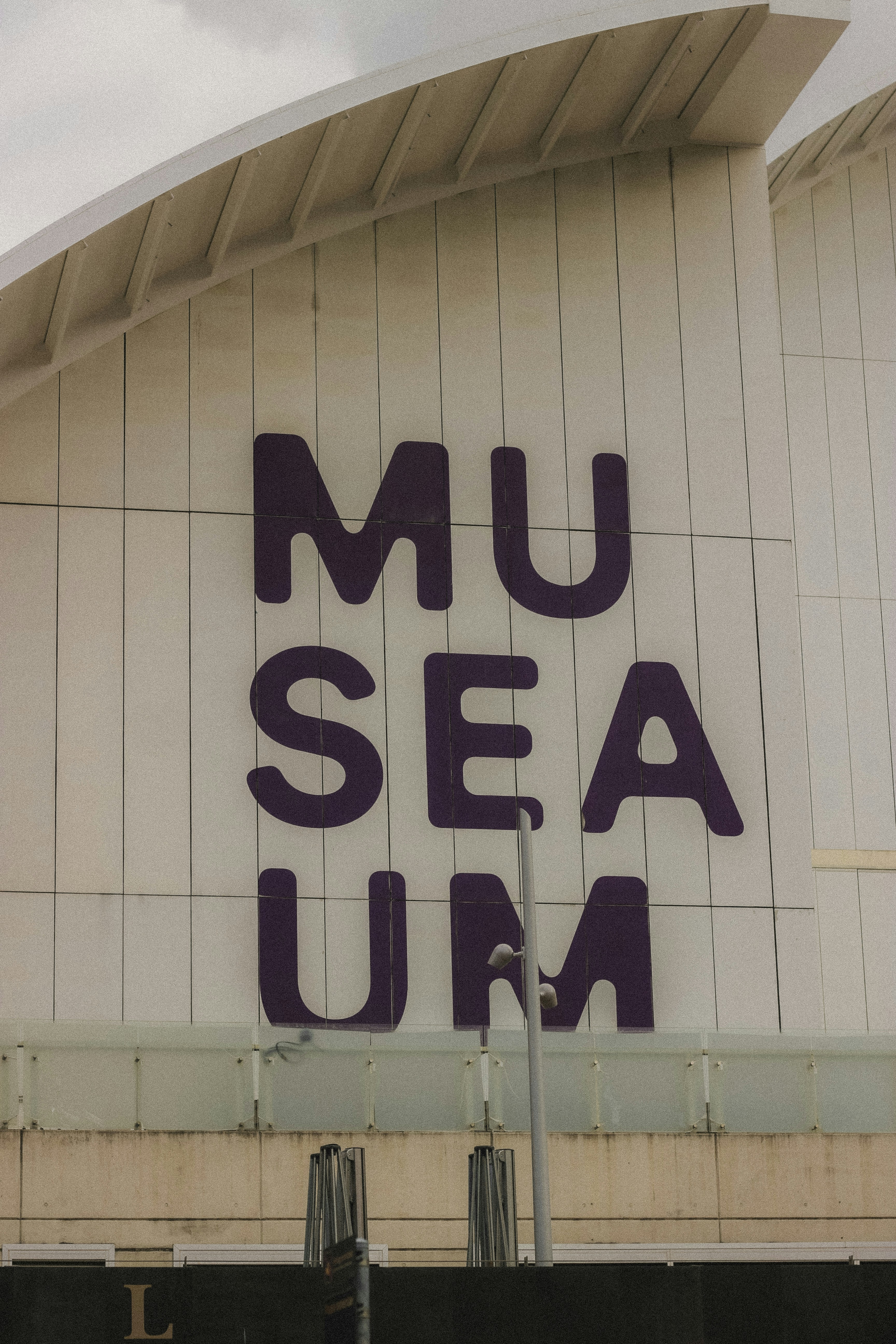 Grandes letras moradas en un museo de hechizos en un edificio.