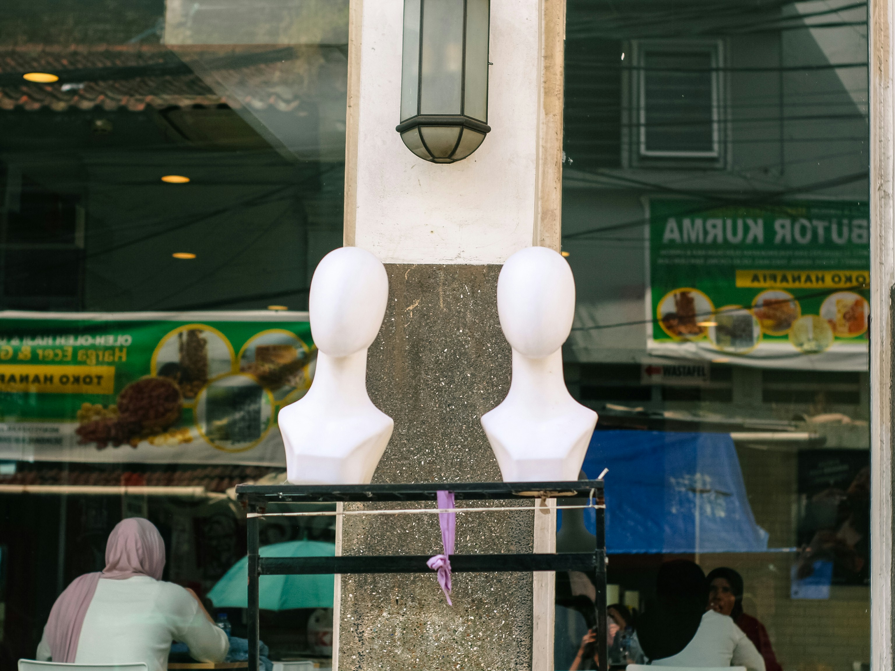 Two white mannequins in a shop window