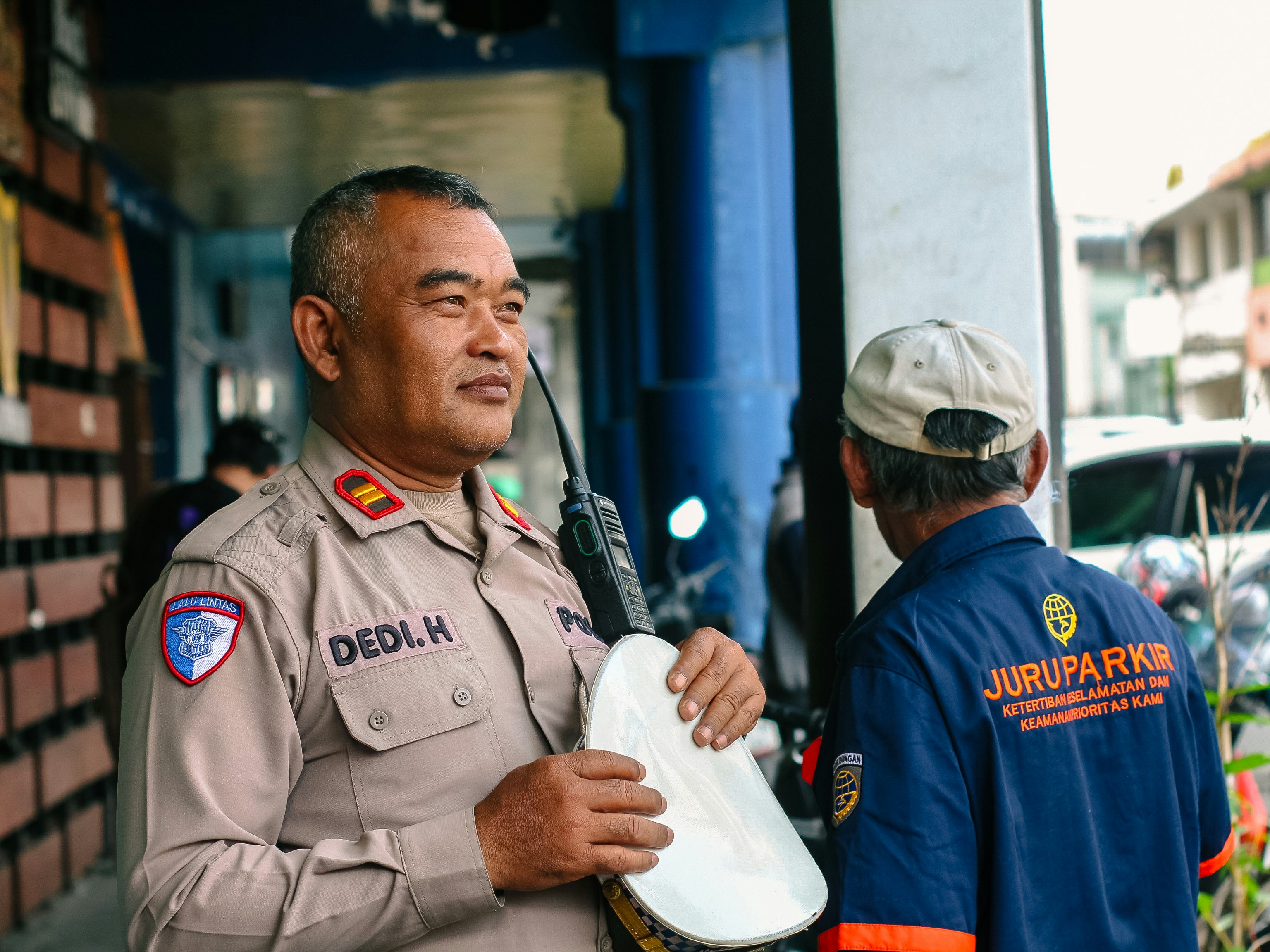 Police officer talking to another man outdoors.