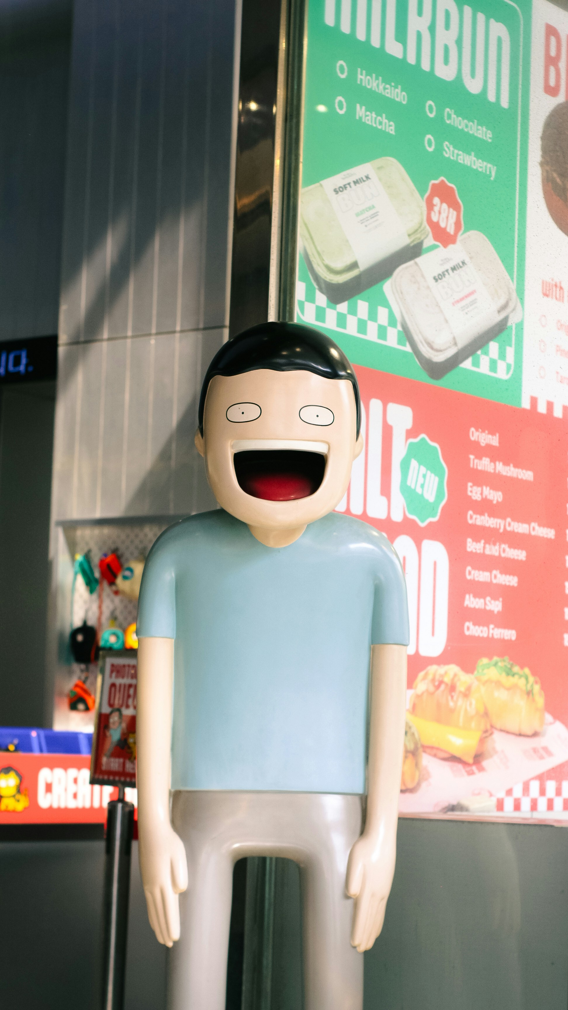 A cartoonish figure with a wide open mouth stands indoors.